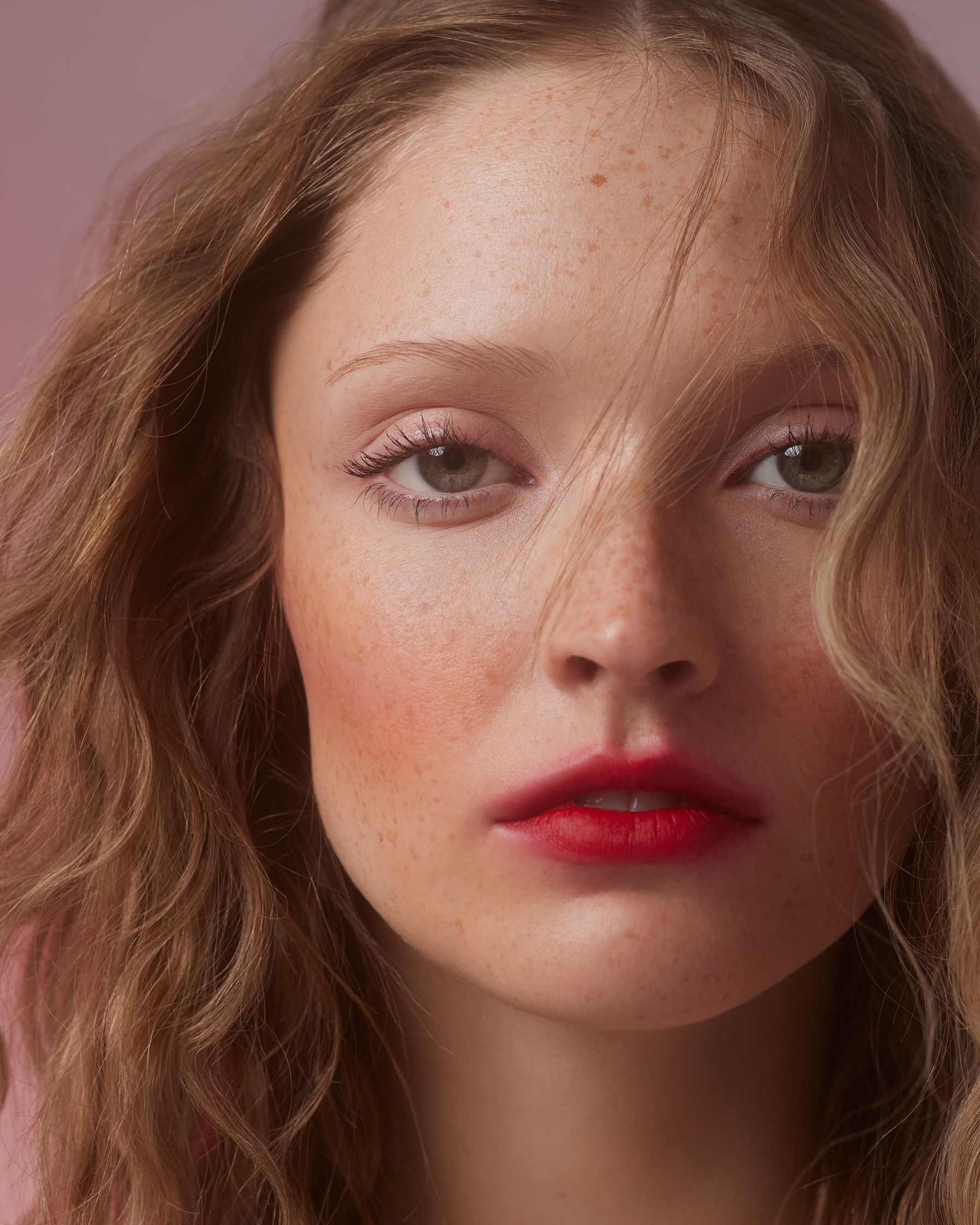 a young woman with freckles and red lipstick