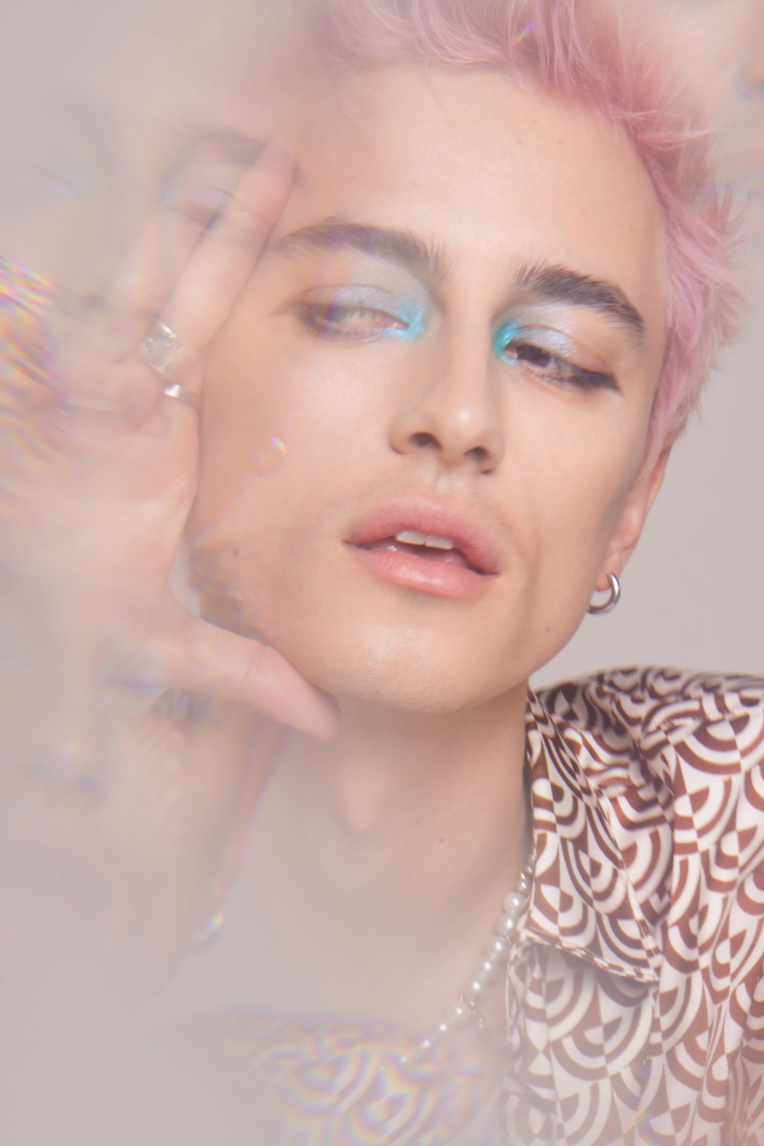 a young man with pink hair is posing in front of a bubble