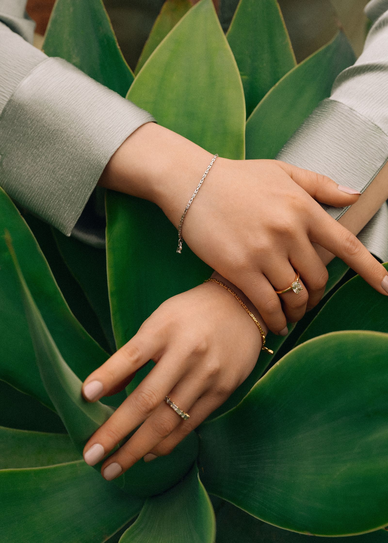 a woman's hands resting on a green plant