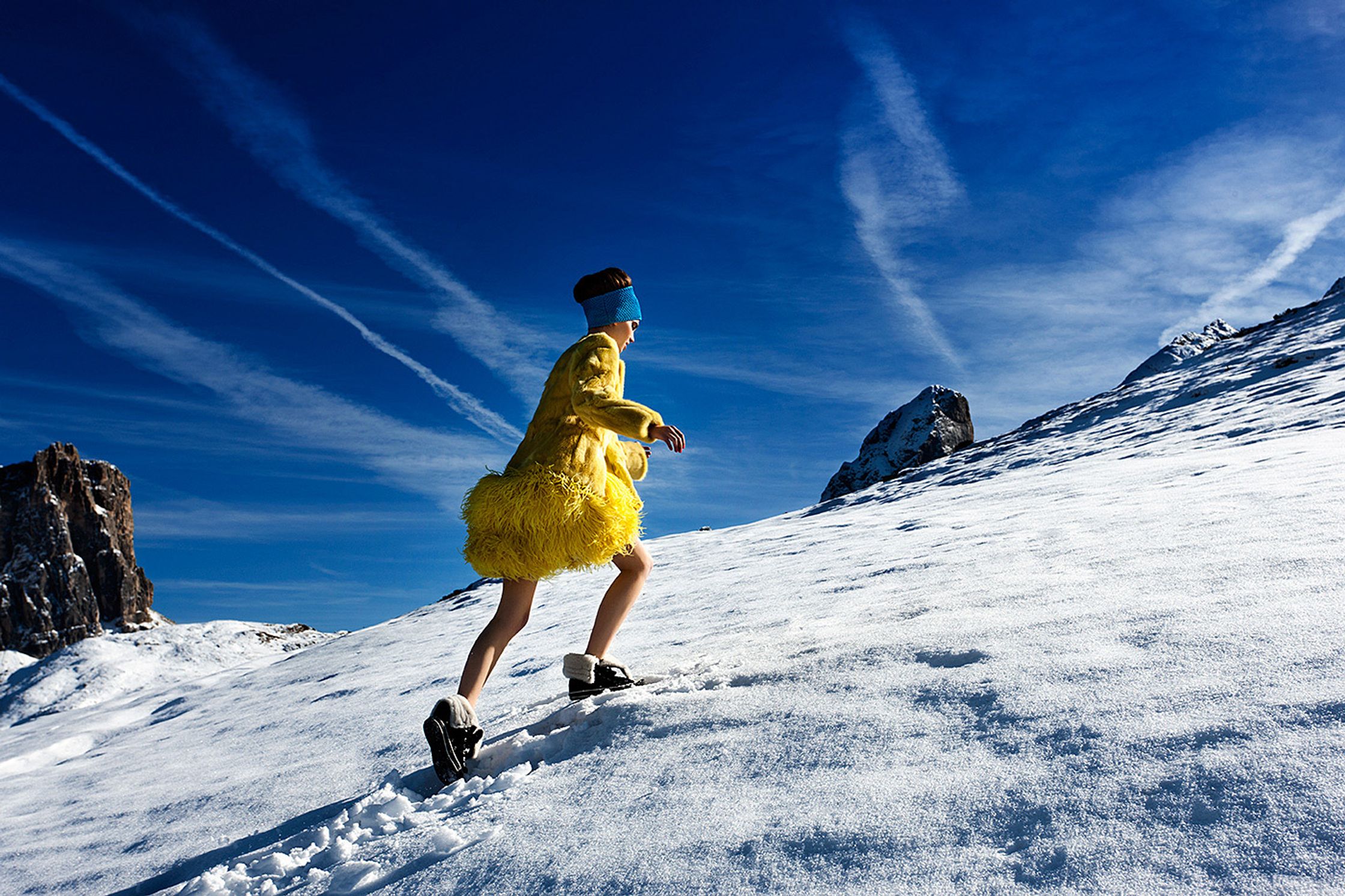 a woman in a yellow dress walking down a snowy hill fashion retouching