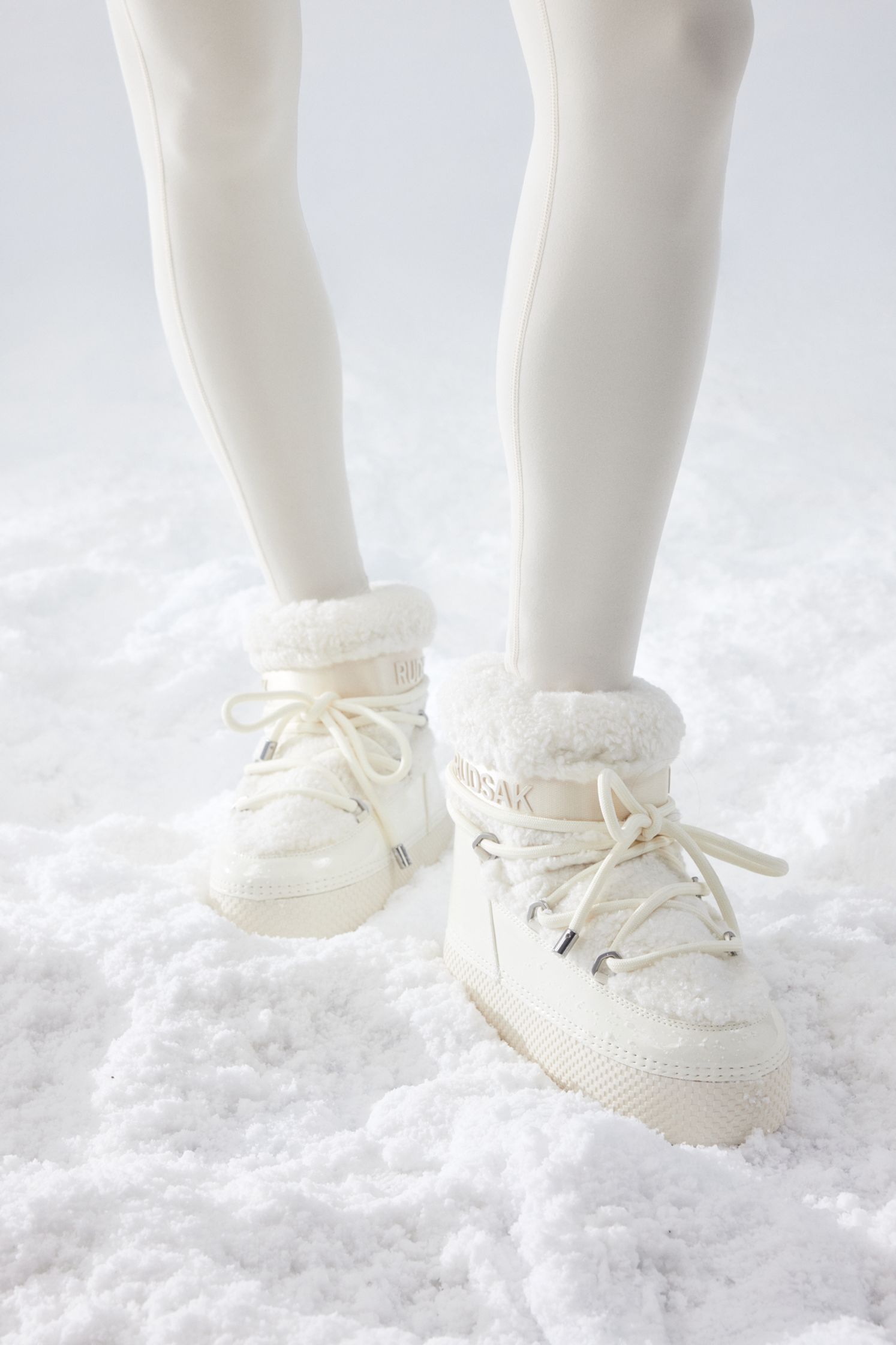 a pair of white sneakers standing in the snow