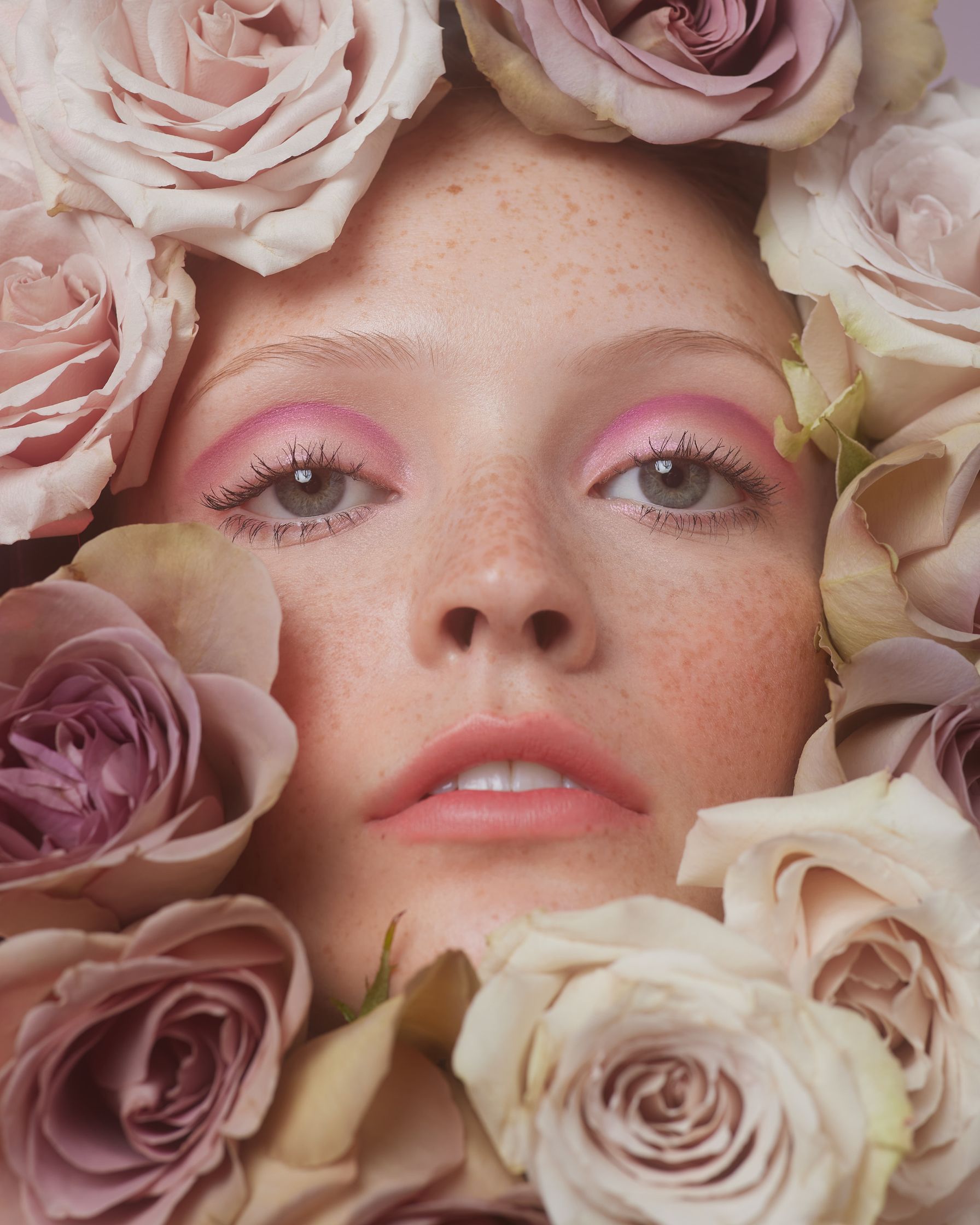 a woman's face is surrounded by roses