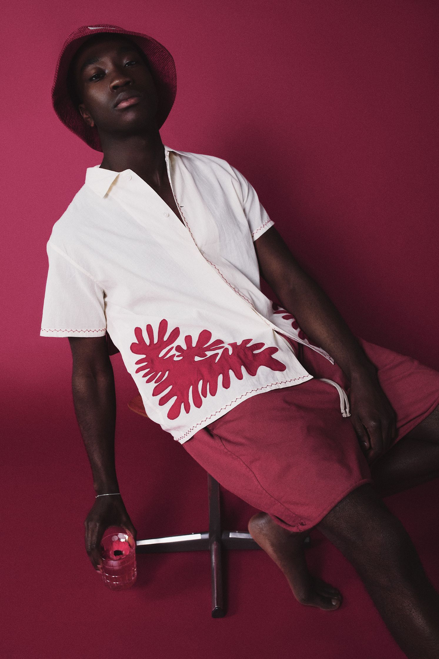 a man sitting on a chair wearing a hat and shorts