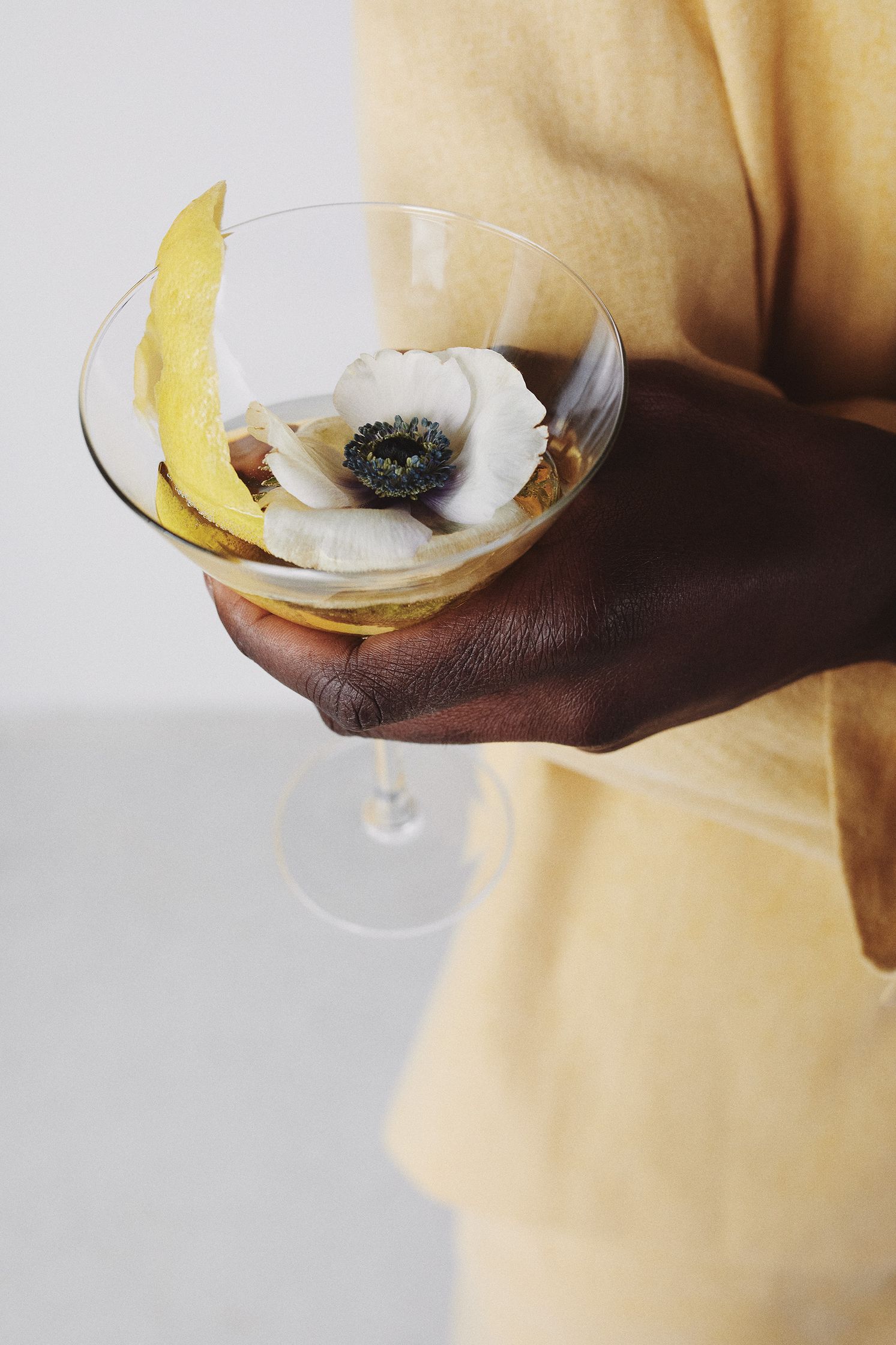 a person holding a glass with a flower in it