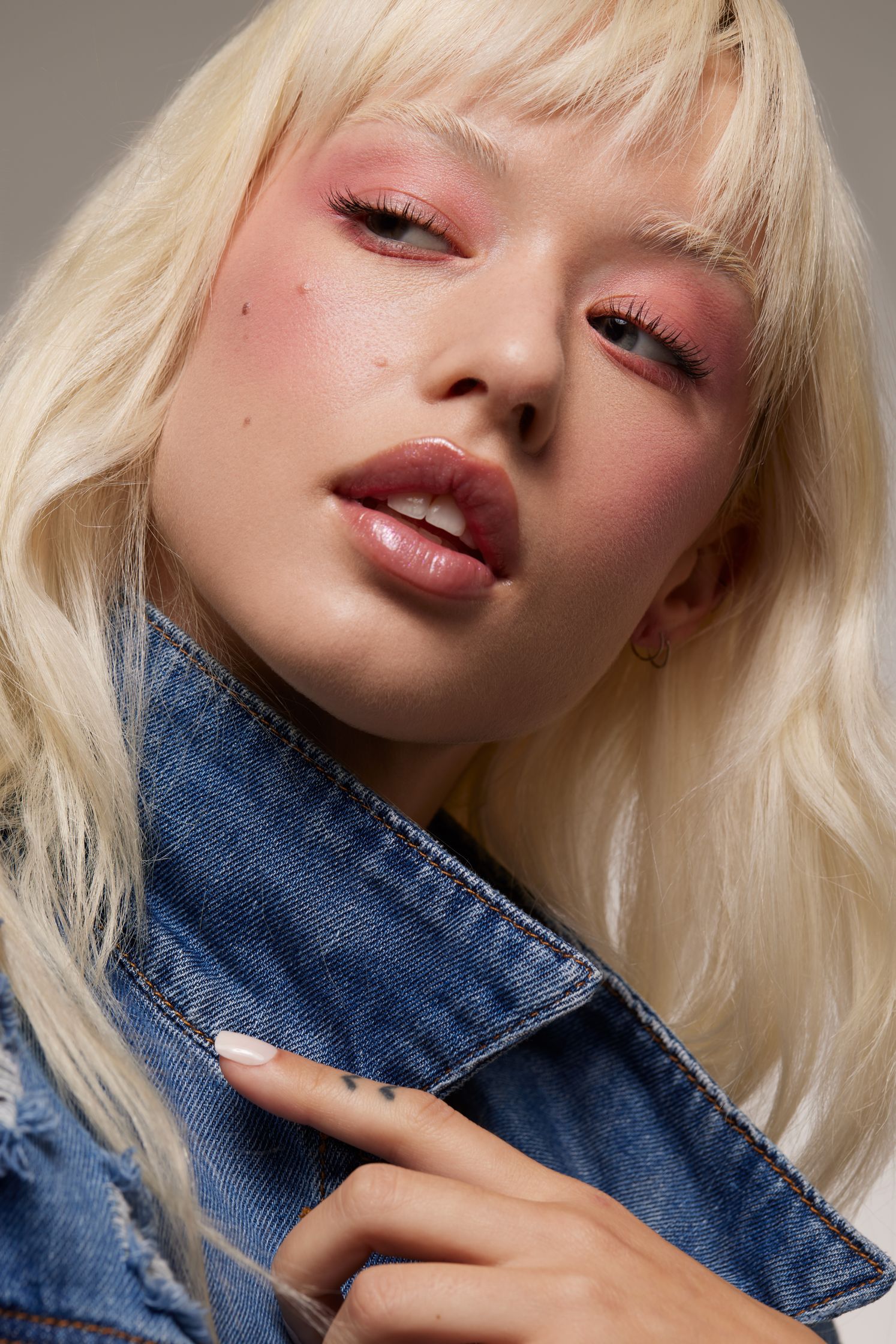 a blonde woman wearing a denim jacket