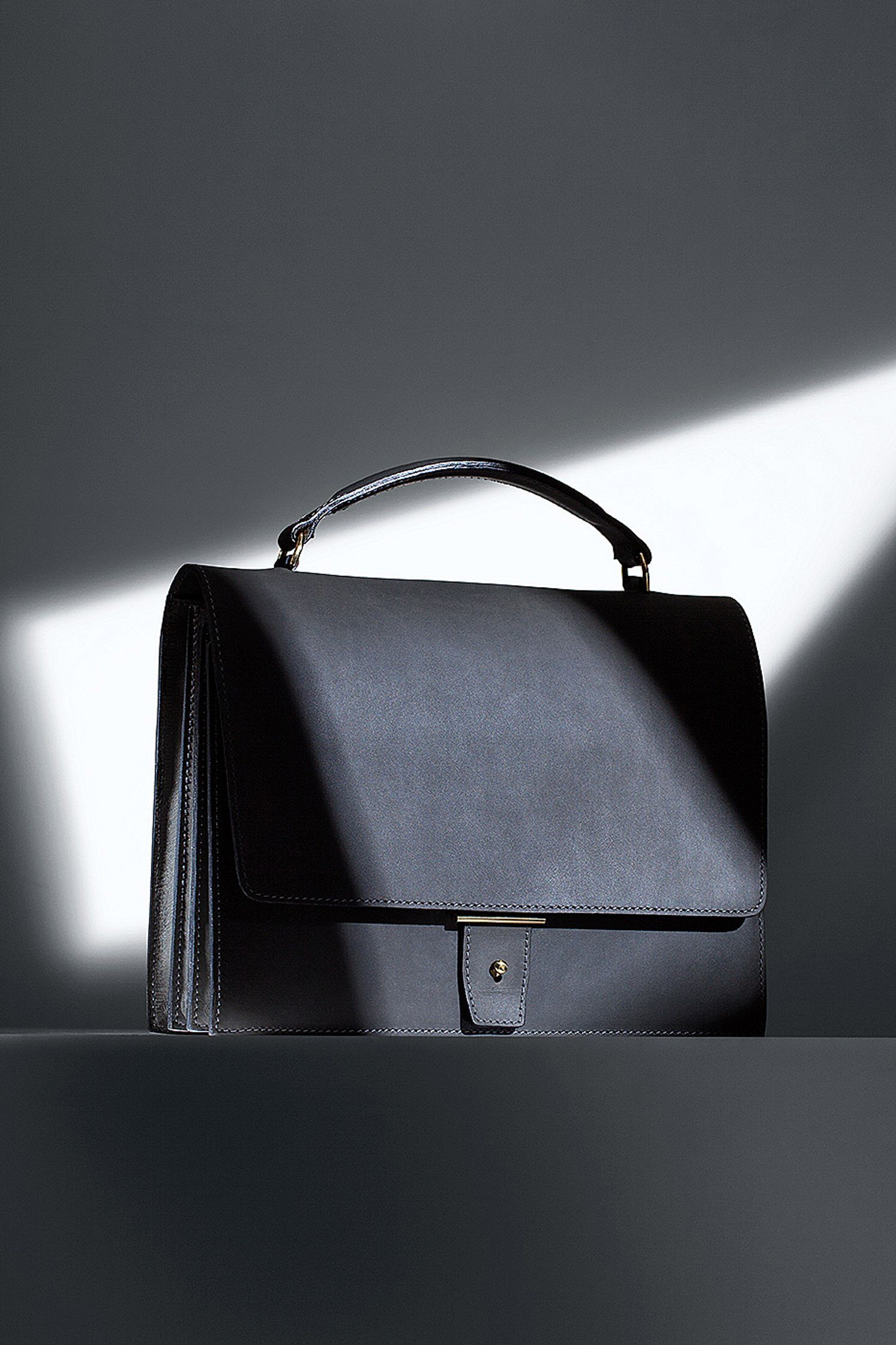 a black handbag with a light shining on it - Bildbearbeitung Hamburg