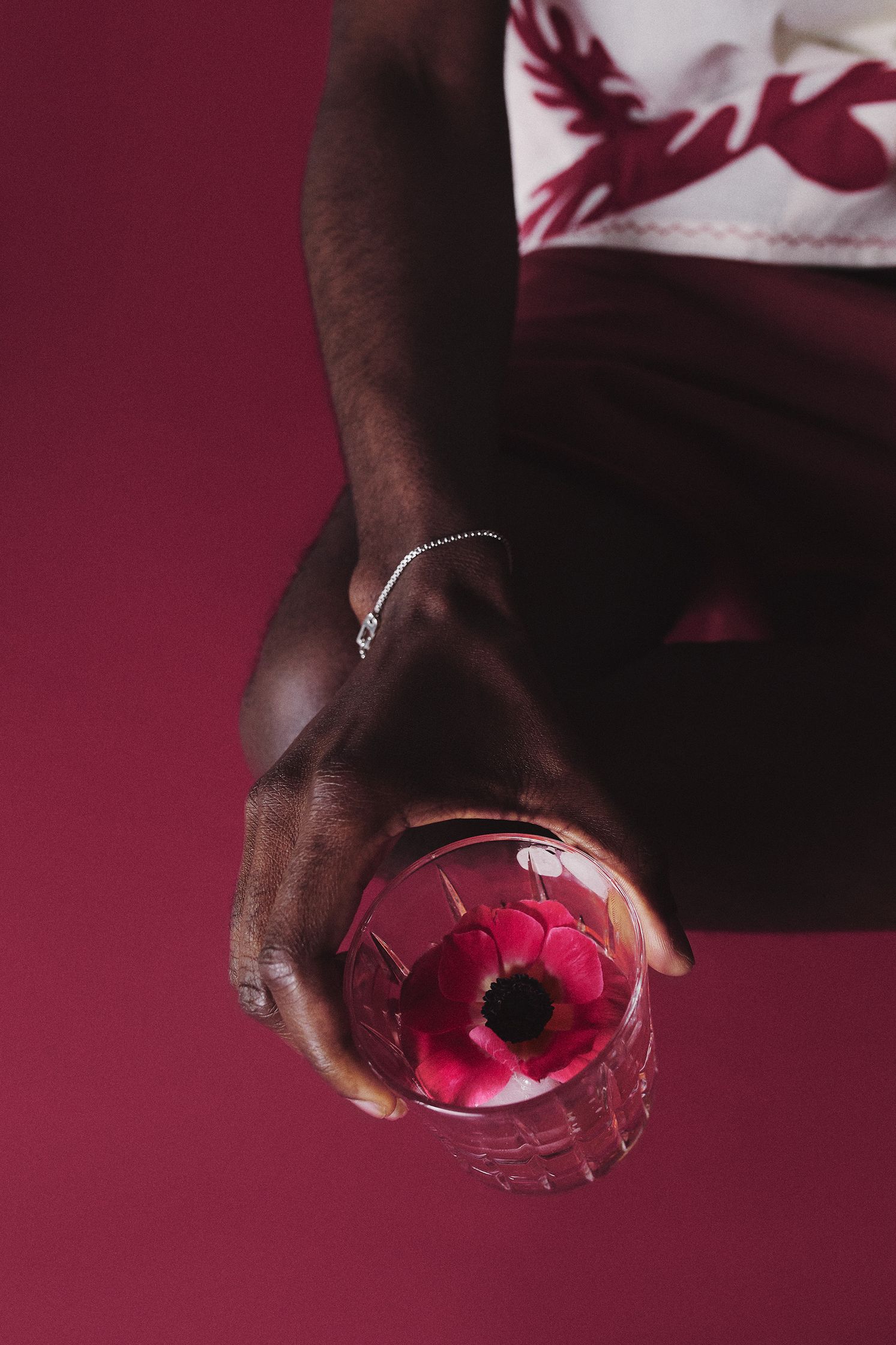 a man holding a glass with a flower in it