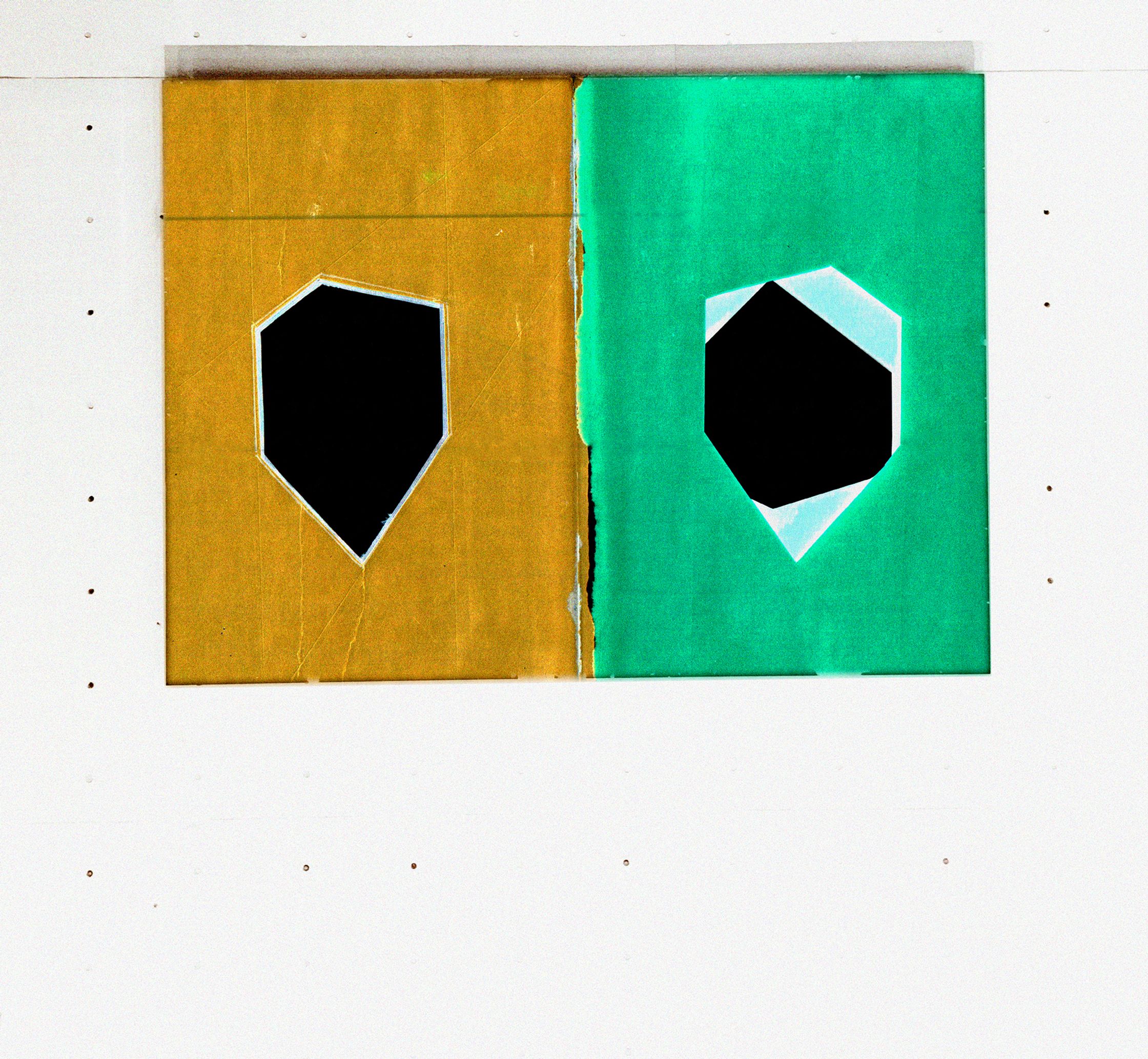 a green and yellow piece of paper on a white wall