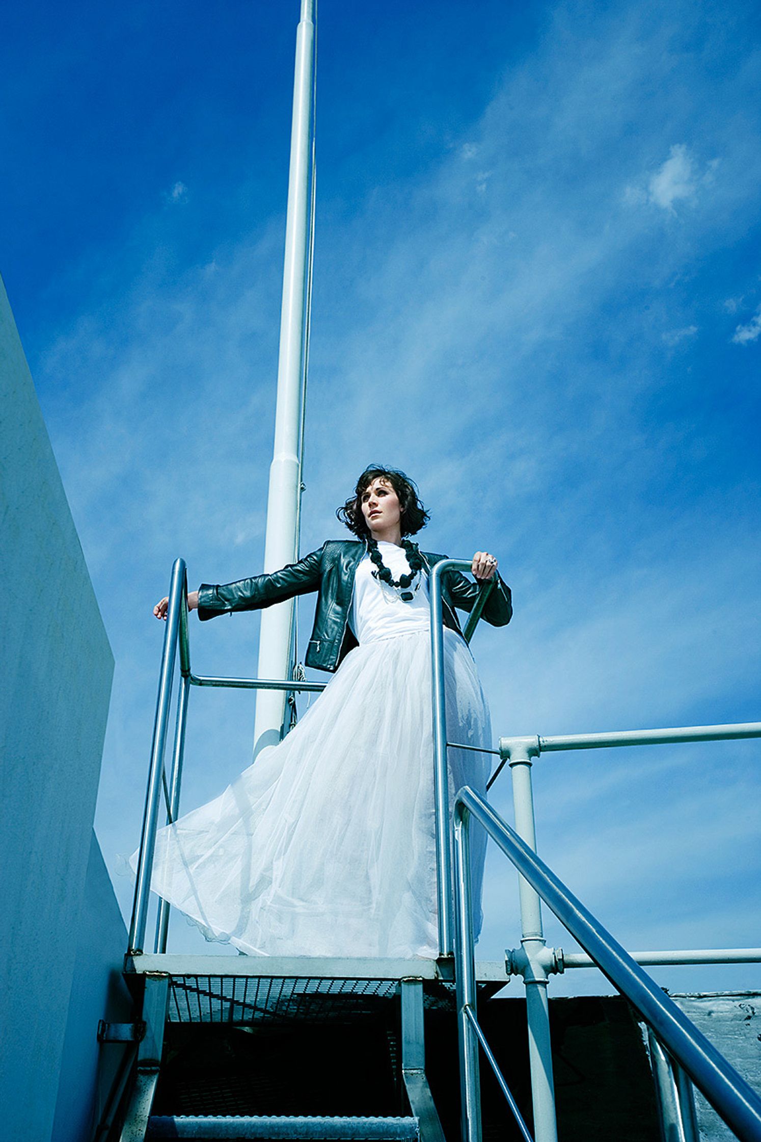 a woman in a white dress standing on stairs editorial fashion retusche