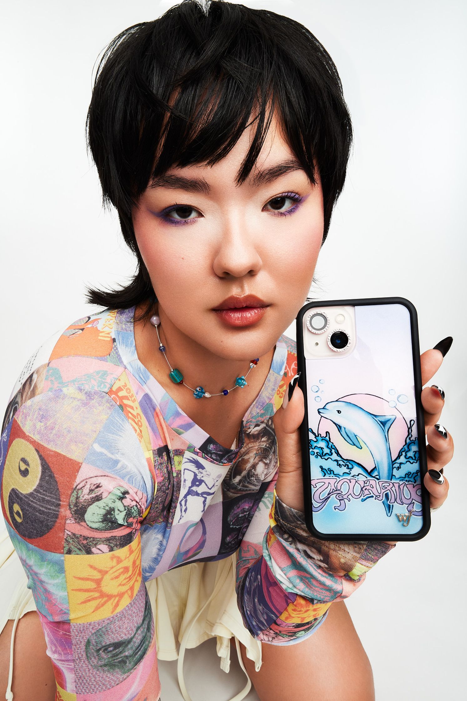 a woman holding up a phone case with a drawing of a whale