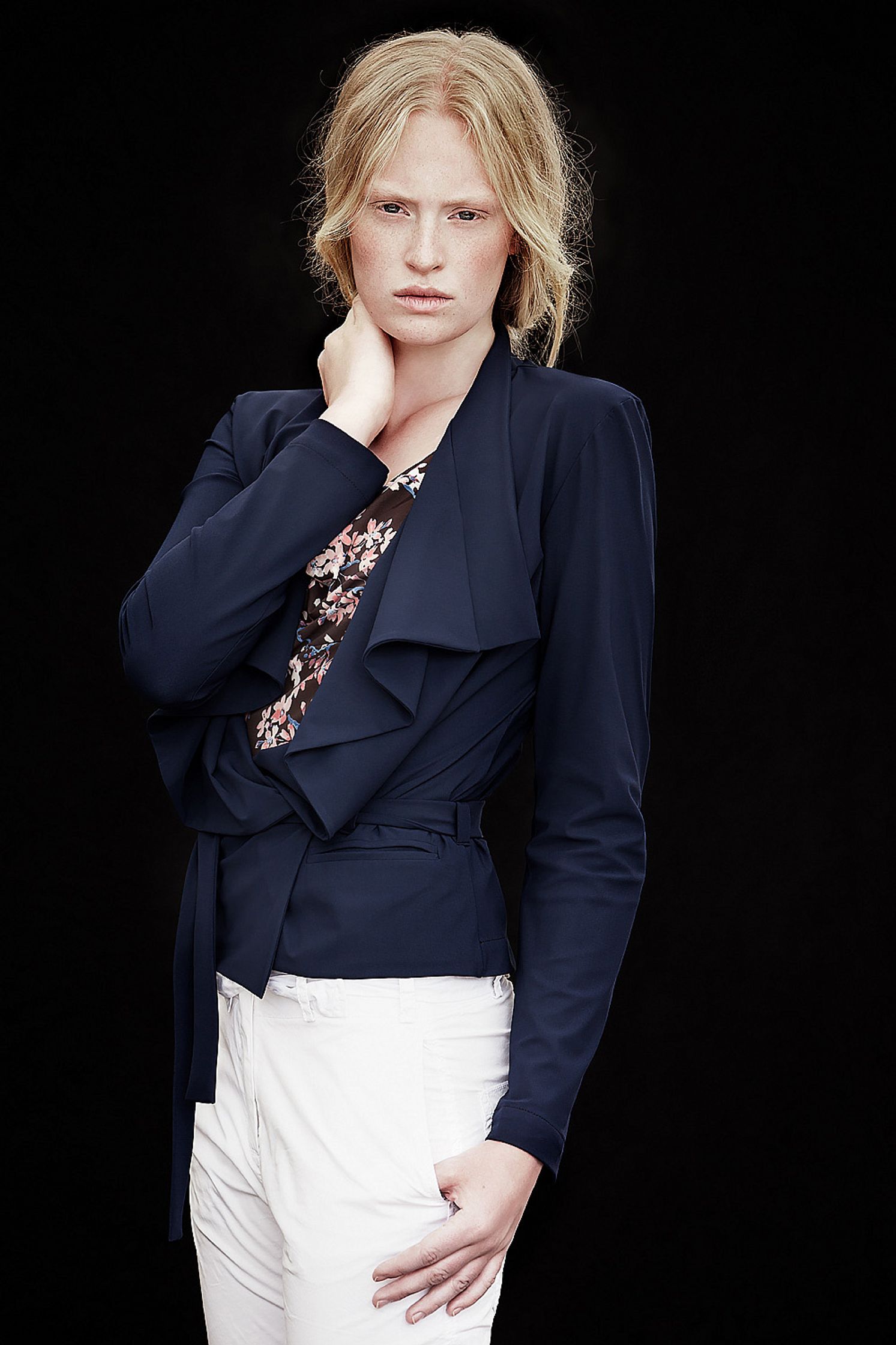 a woman wearing a blue jacket and white pants natural retouch campaign