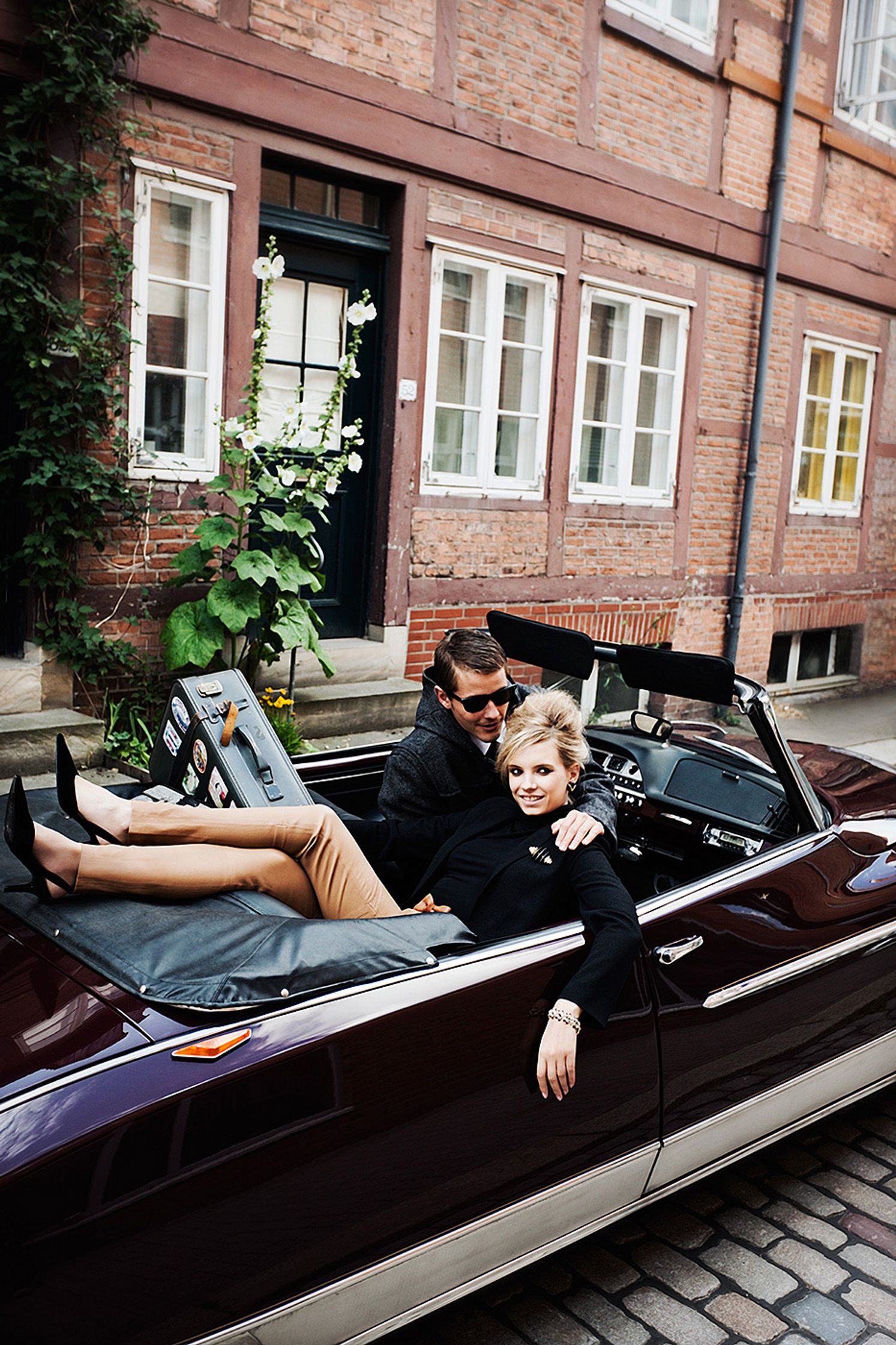 a man and woman sitting in a convertible car creative retouch and look