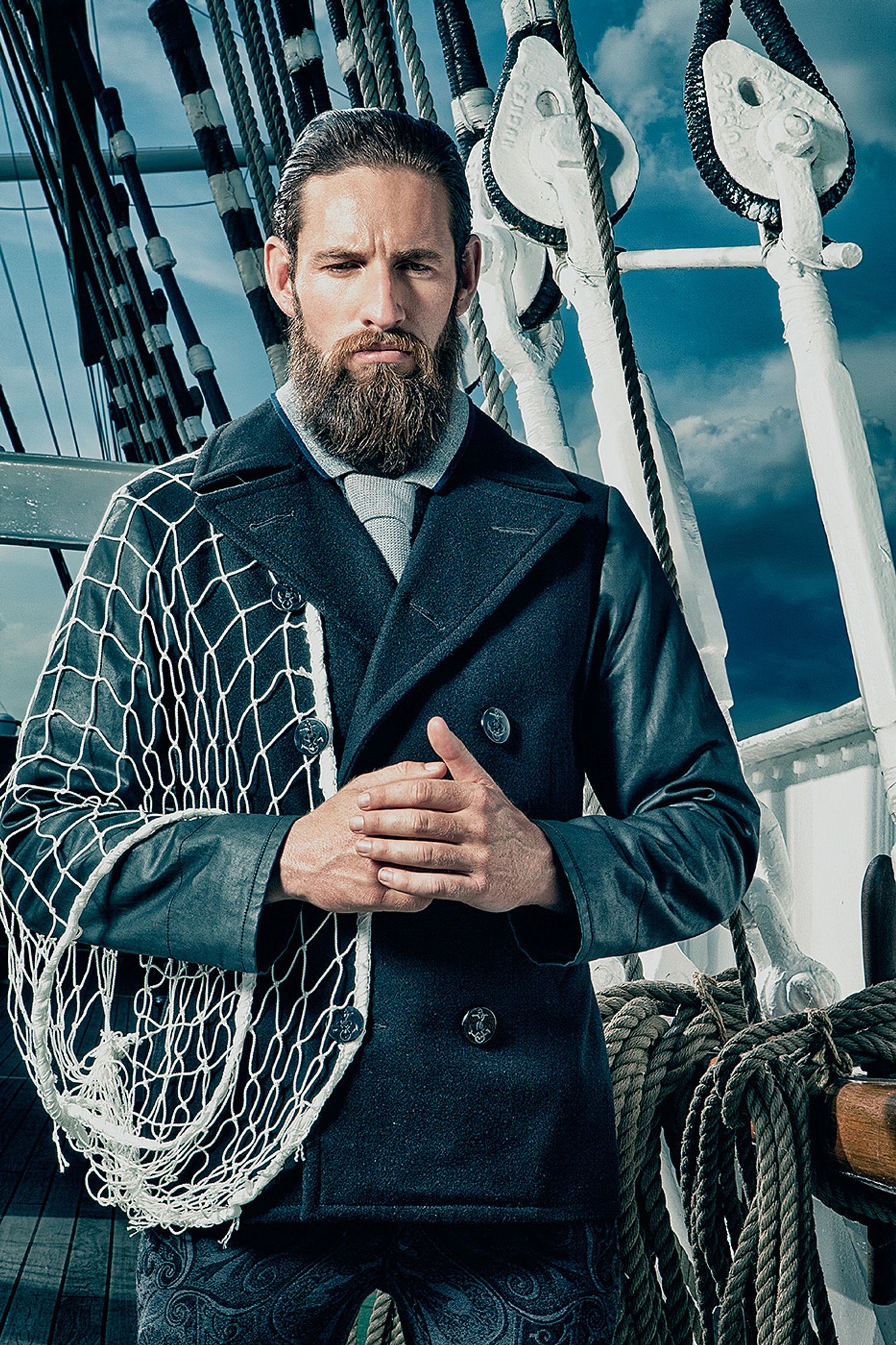 a man with a beard standing on the deck of a ship Creative Retouching Hamburg