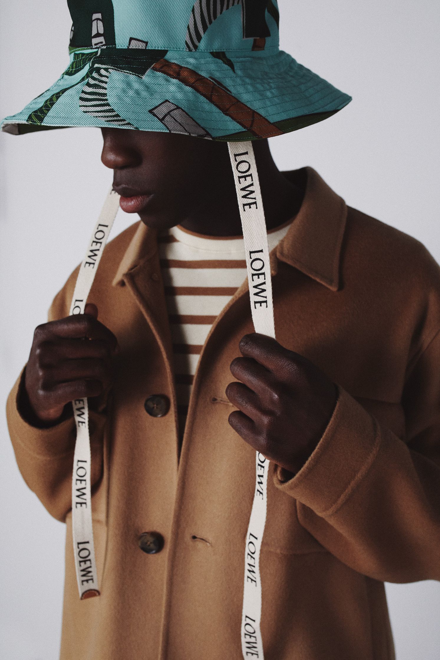 a man wearing a bucket hat and striped shirt