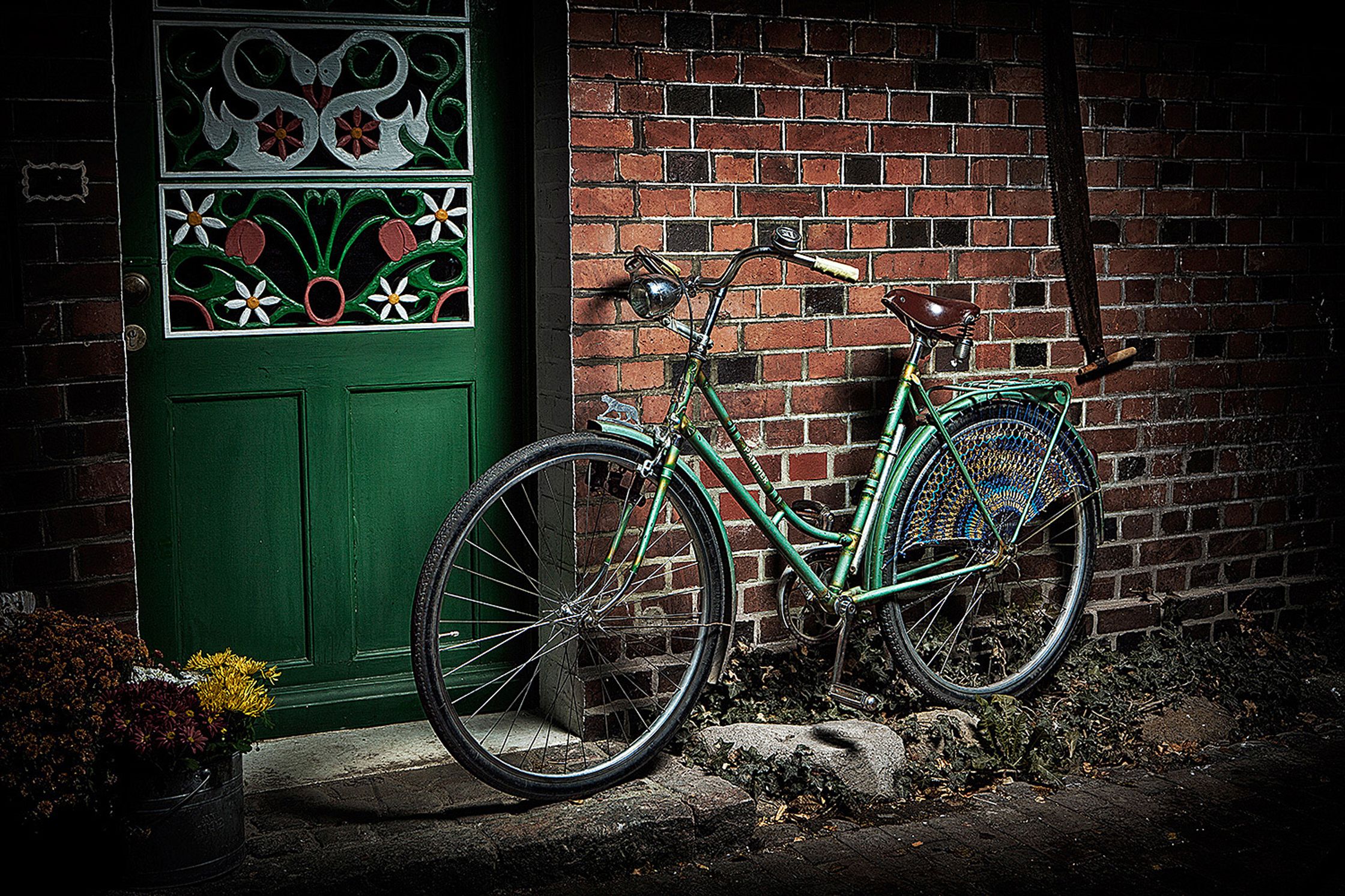 a old green bicycle leaning against a brick wall Bildbearbeitung Hamburg