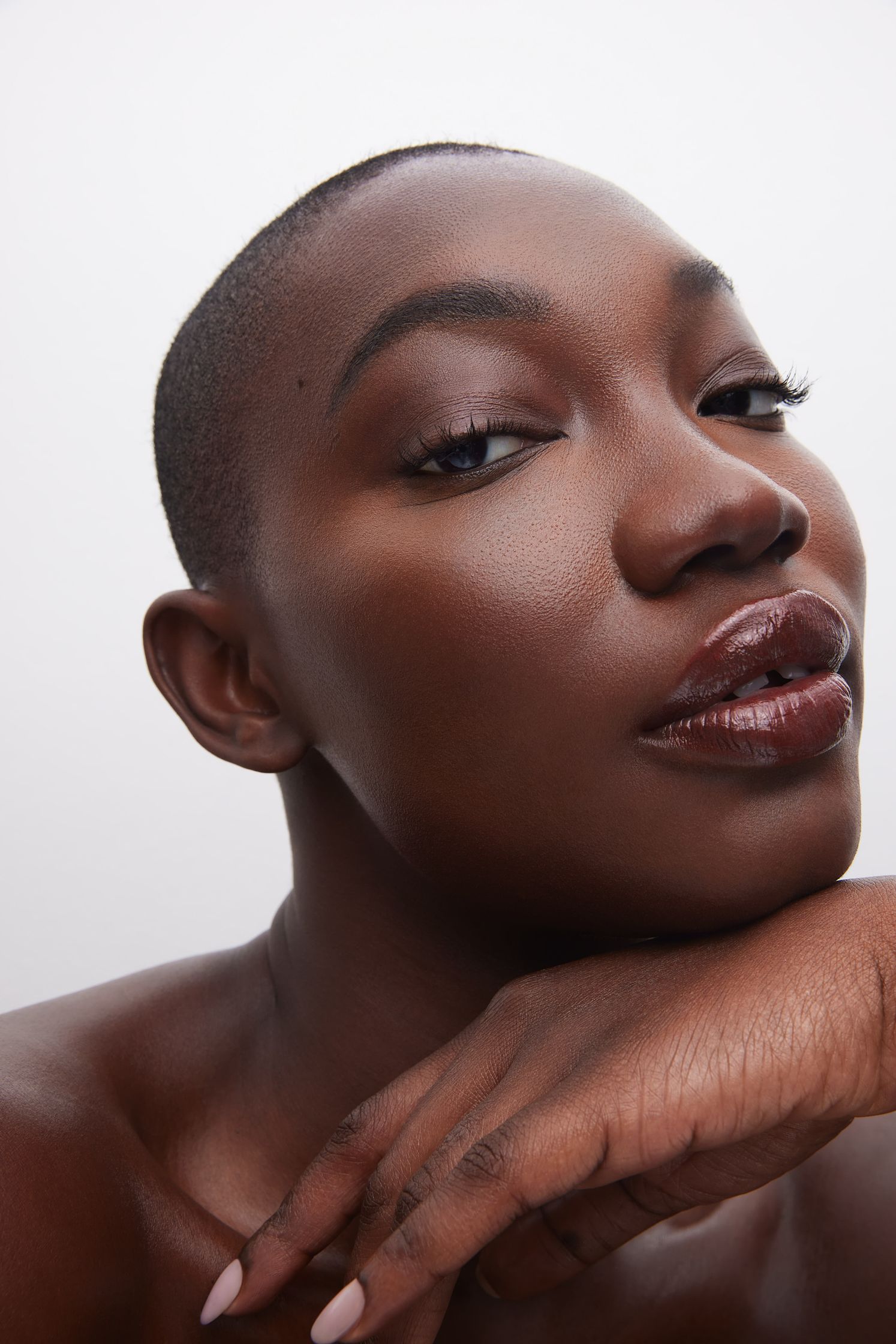 a black woman posing with her hand on her chin