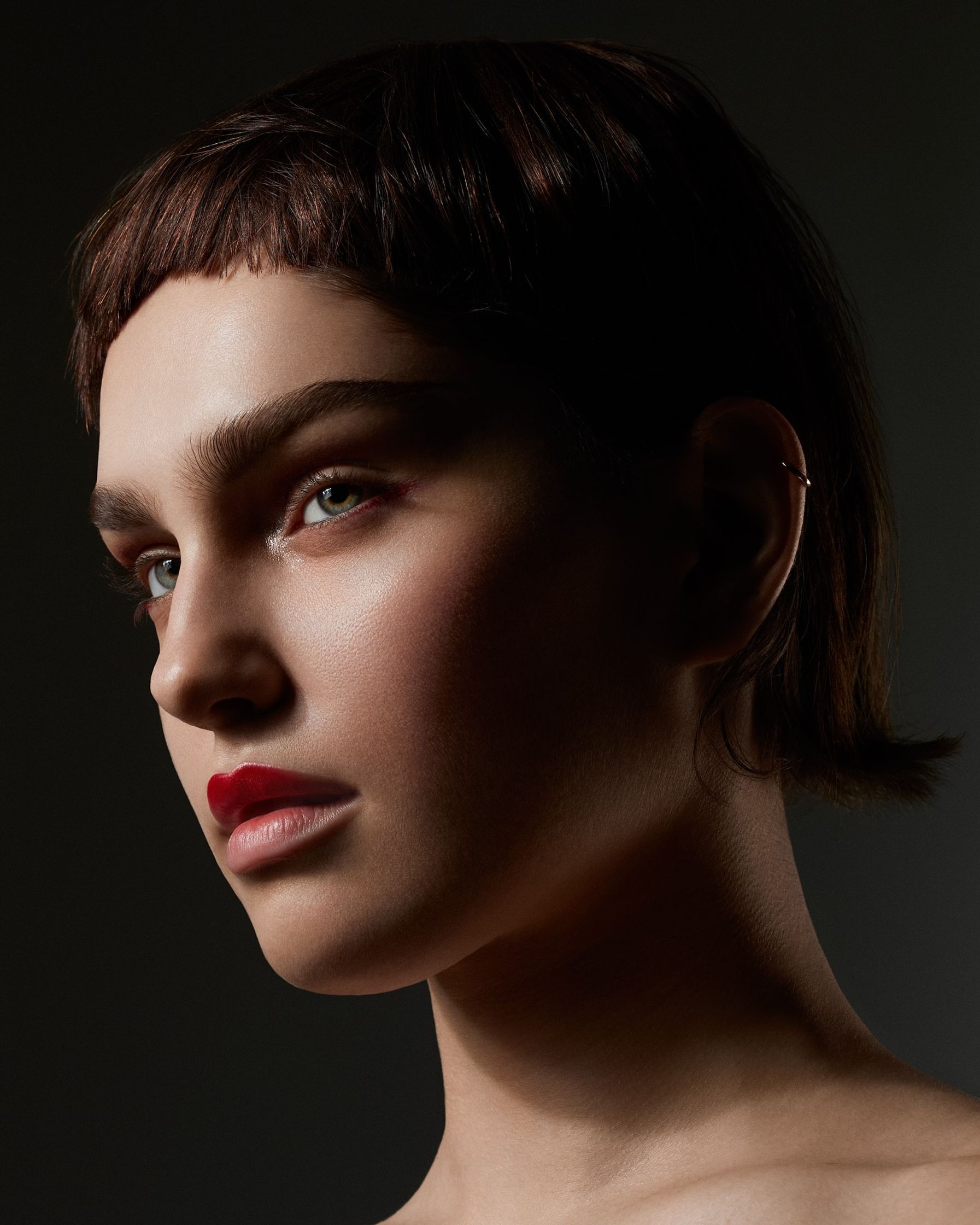 a woman with a short haircut and red lipstick