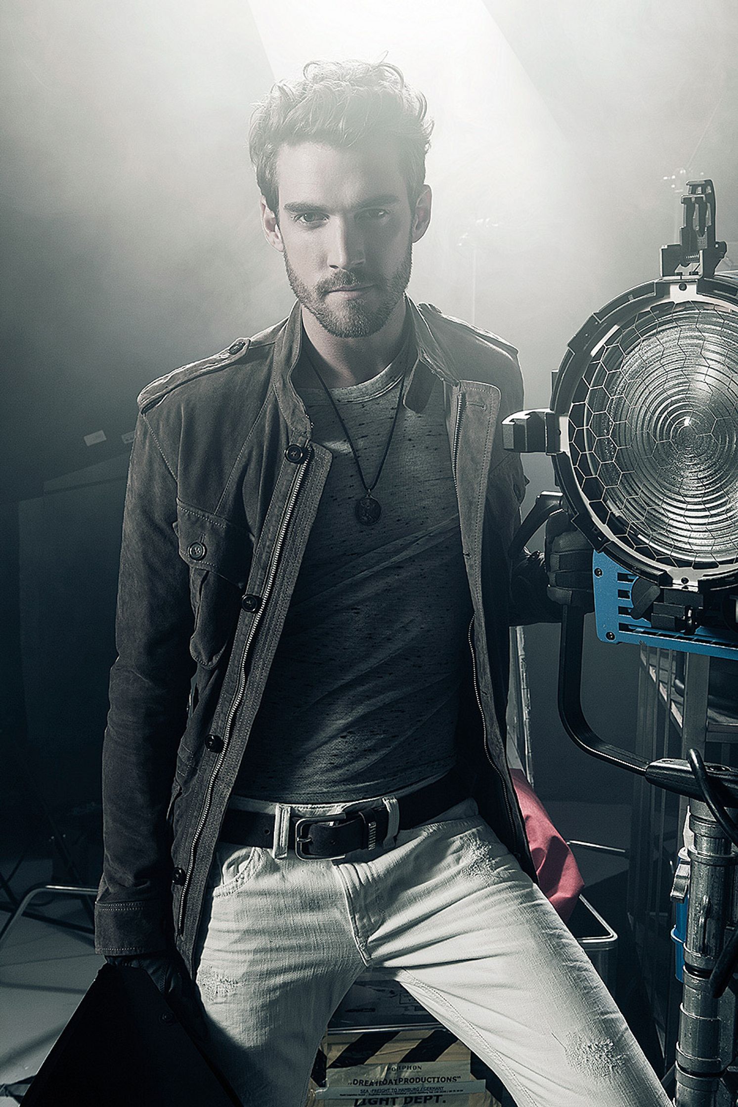 a man posing in front of a light stand Post Production Hamburg