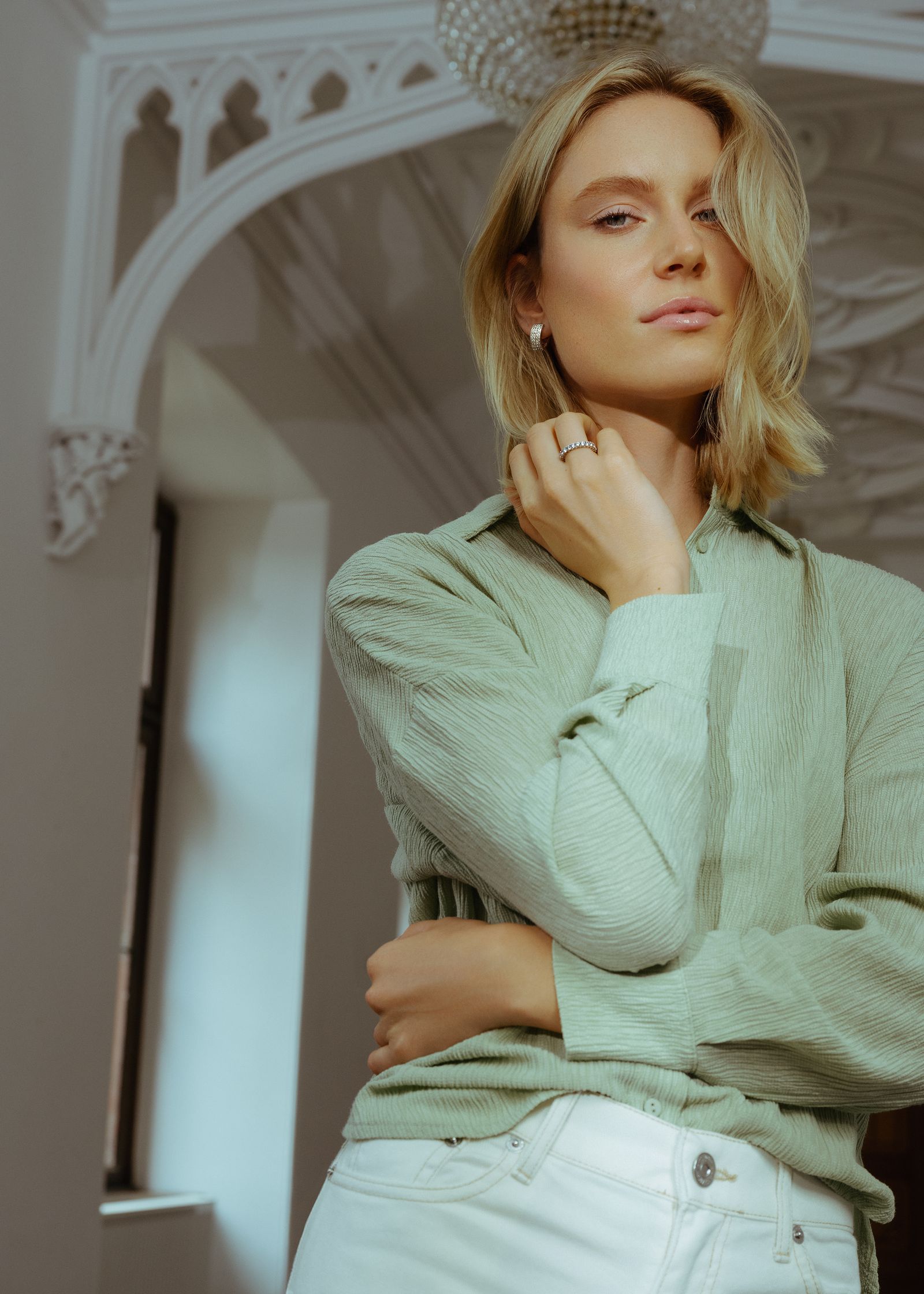 a woman wearing a green shirt and white pants