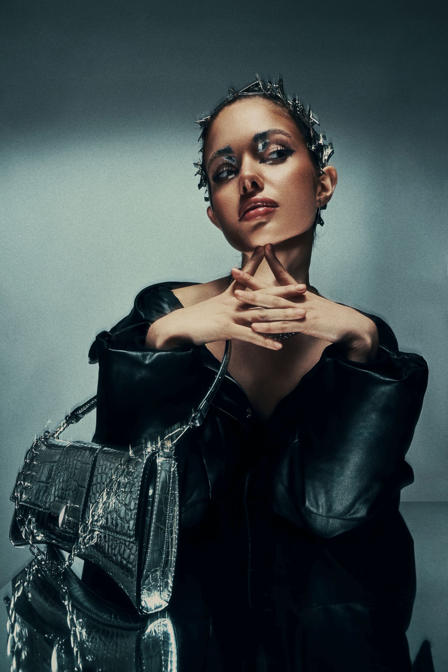 Full-body shot of Monique Bourscheid in a black oversized jacket, posing with a silver handbag.