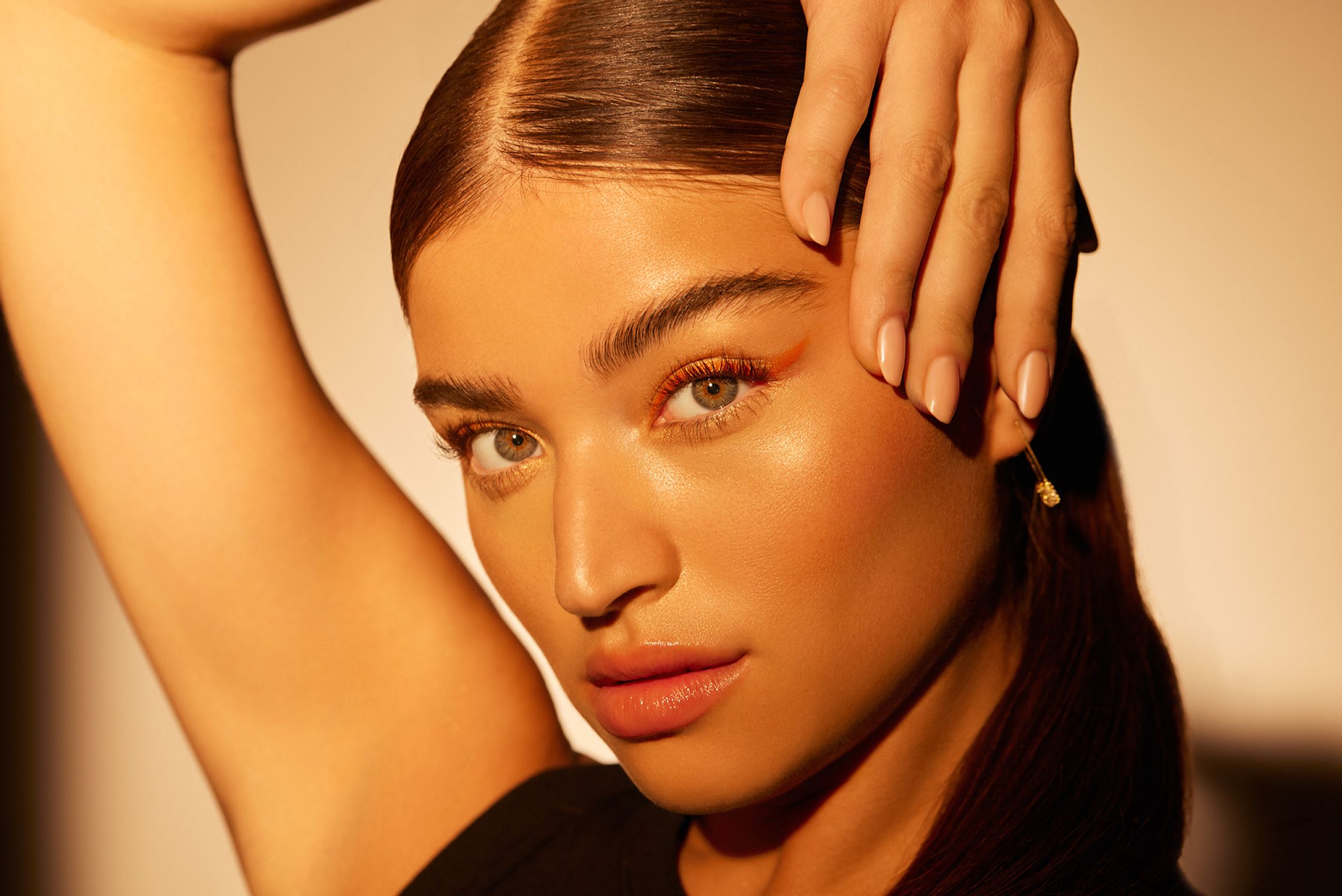 a woman is posing with her hands on her face