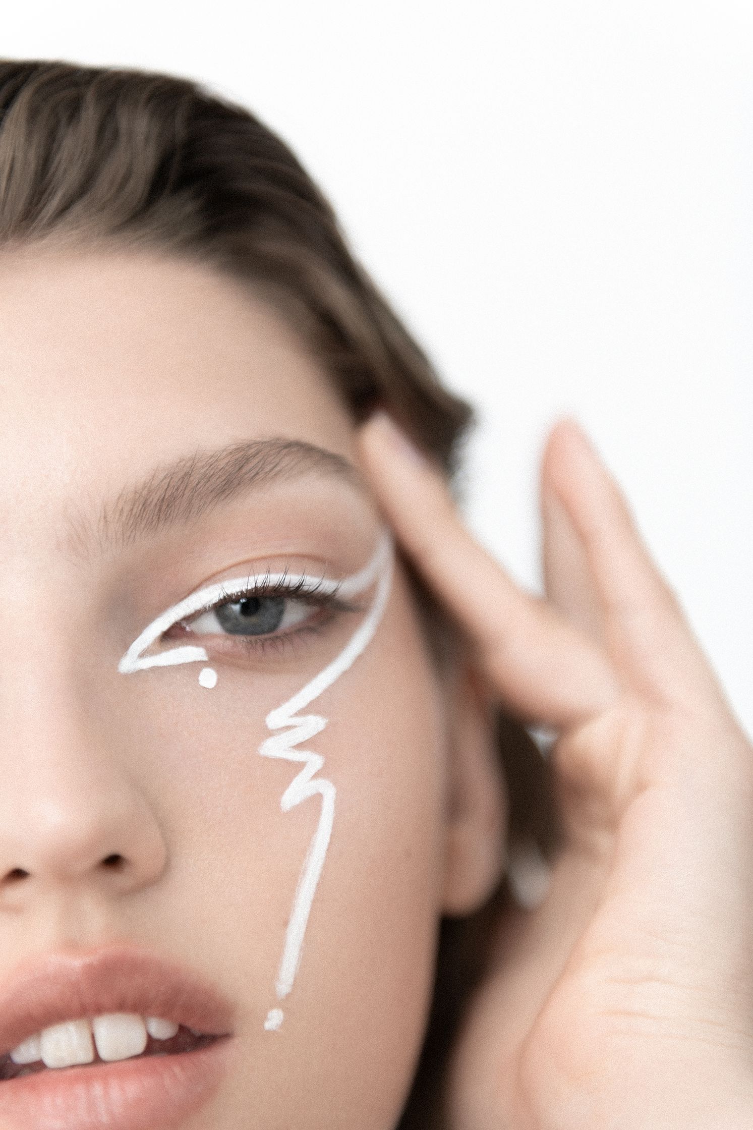 a woman with white makeup on her face