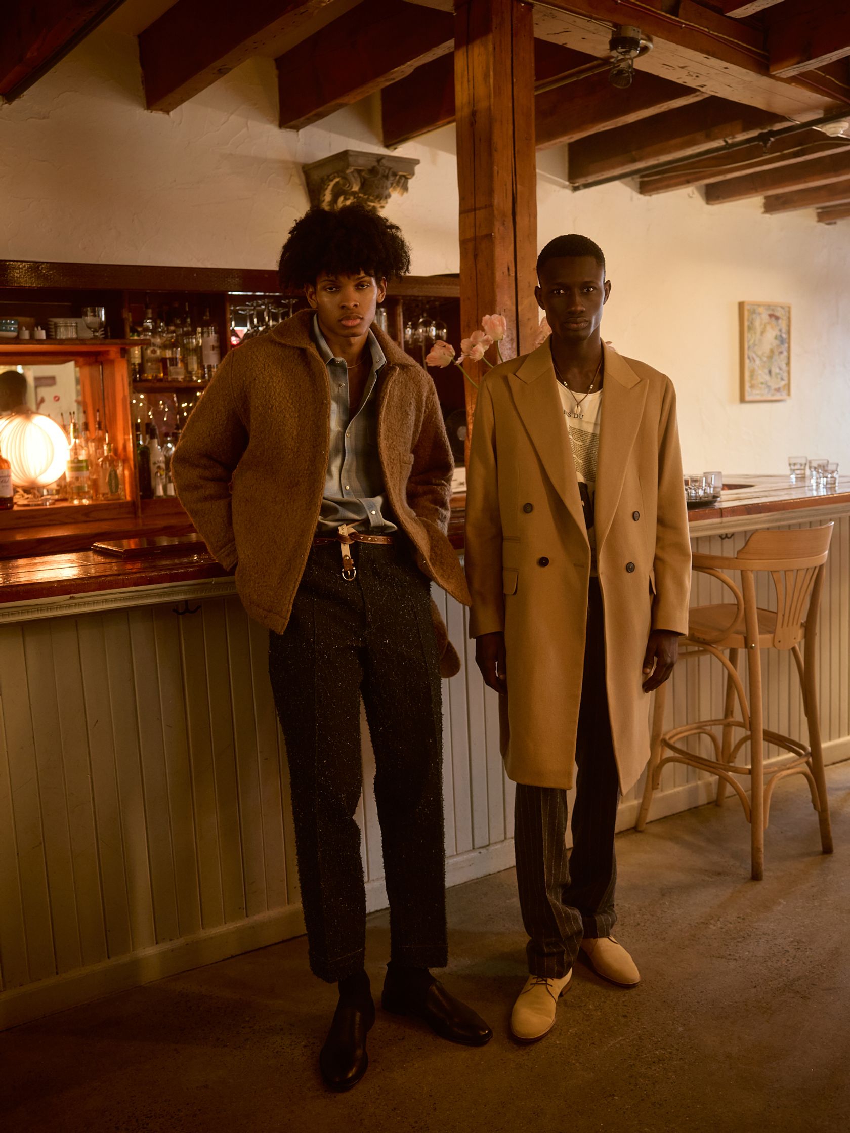 two men standing next to each other in a bar