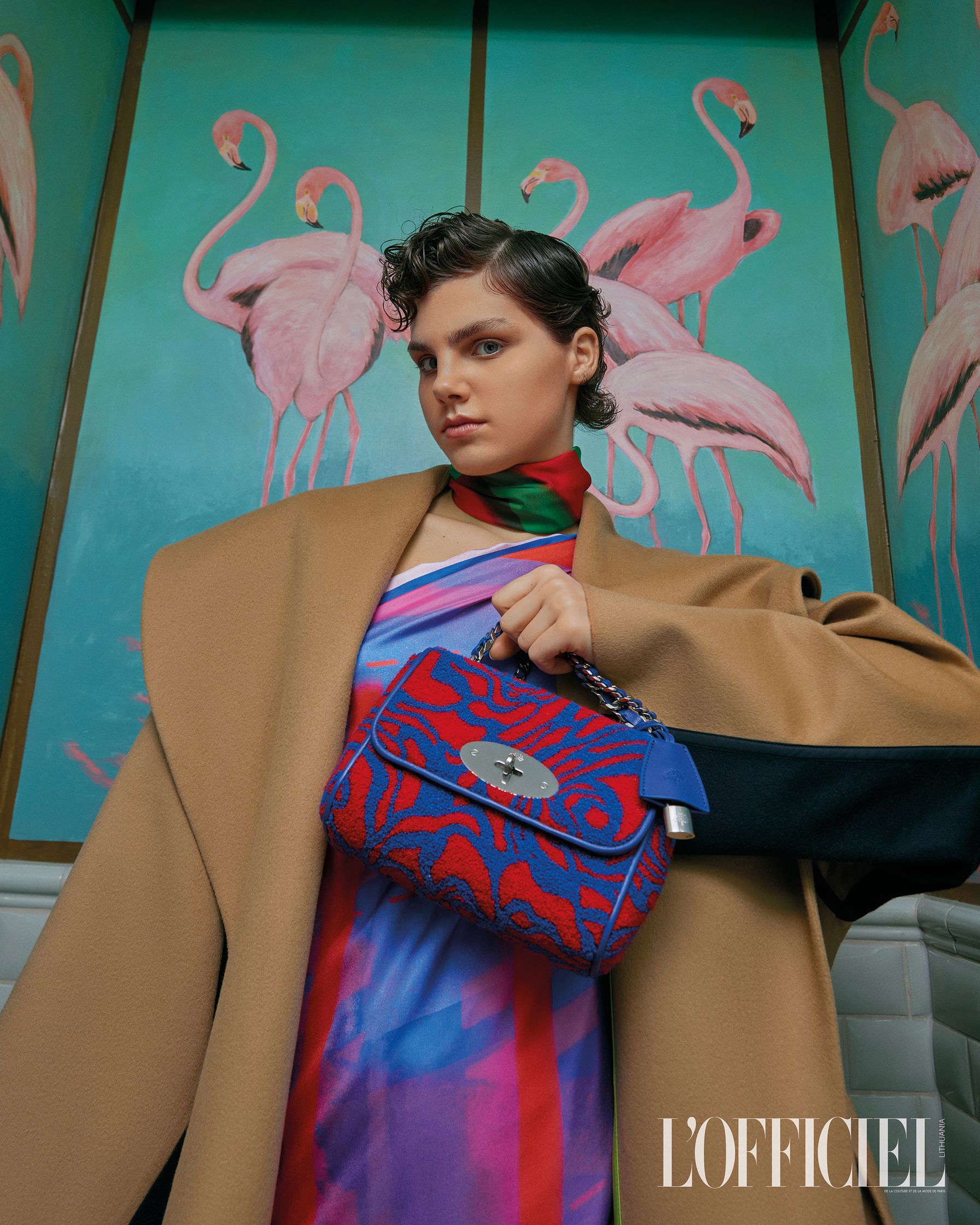 a woman is holding a bag in front of flamingos