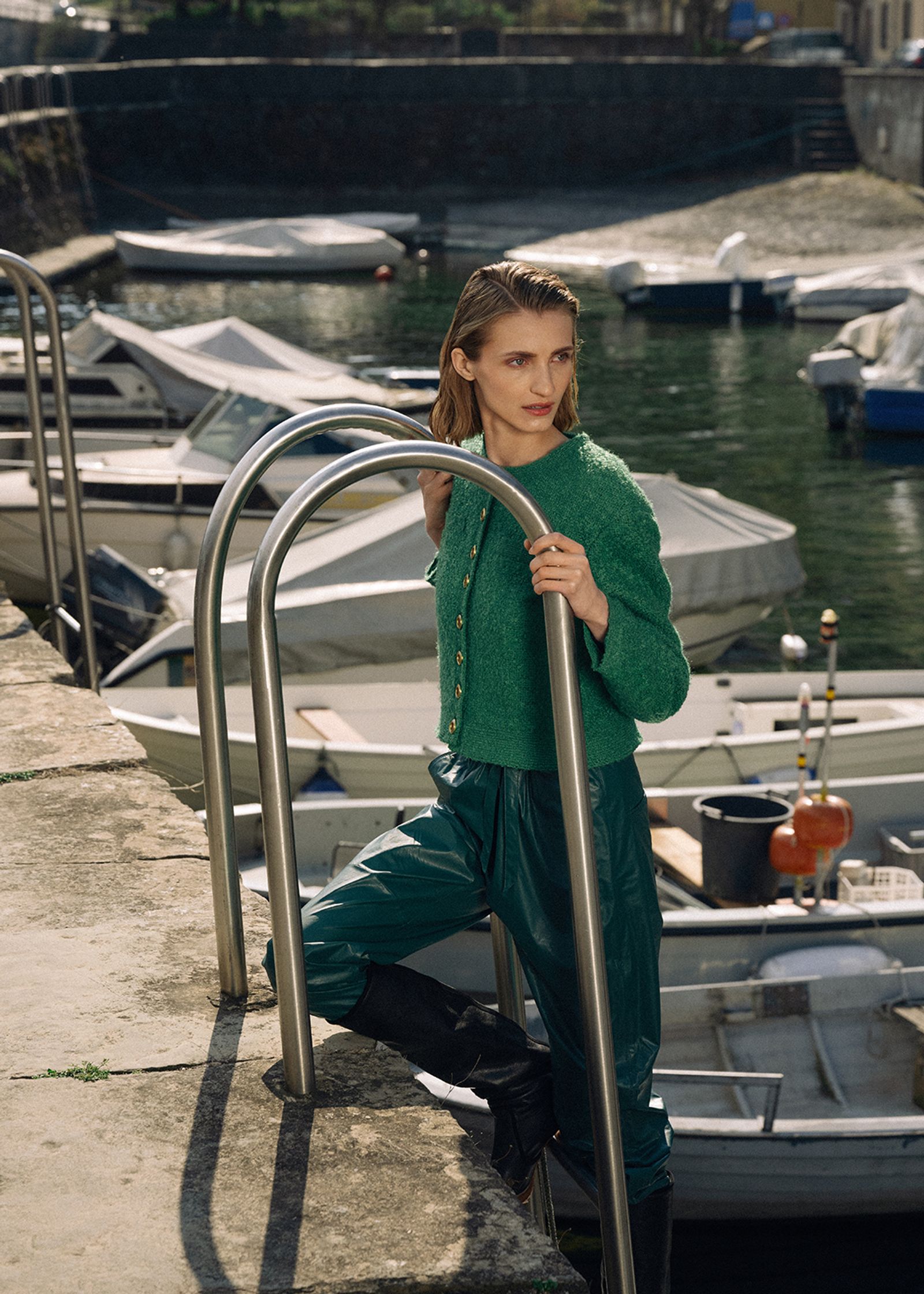 a woman leaning against a railing near a dock