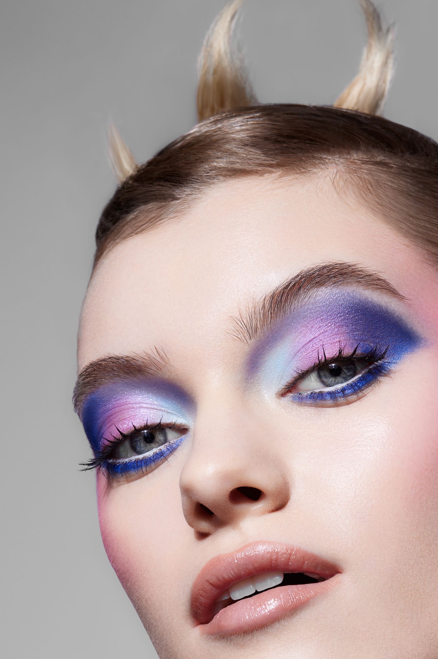 a woman with blue and purple eye makeup