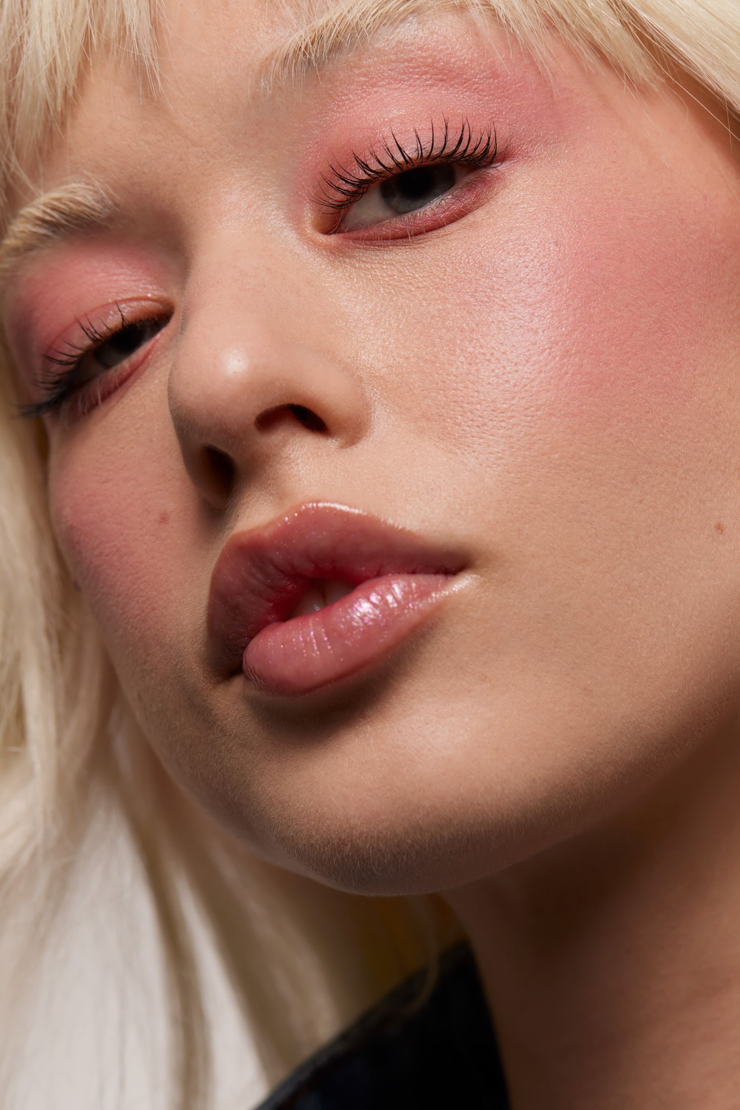 a woman with blond hair and pink eyeshadow