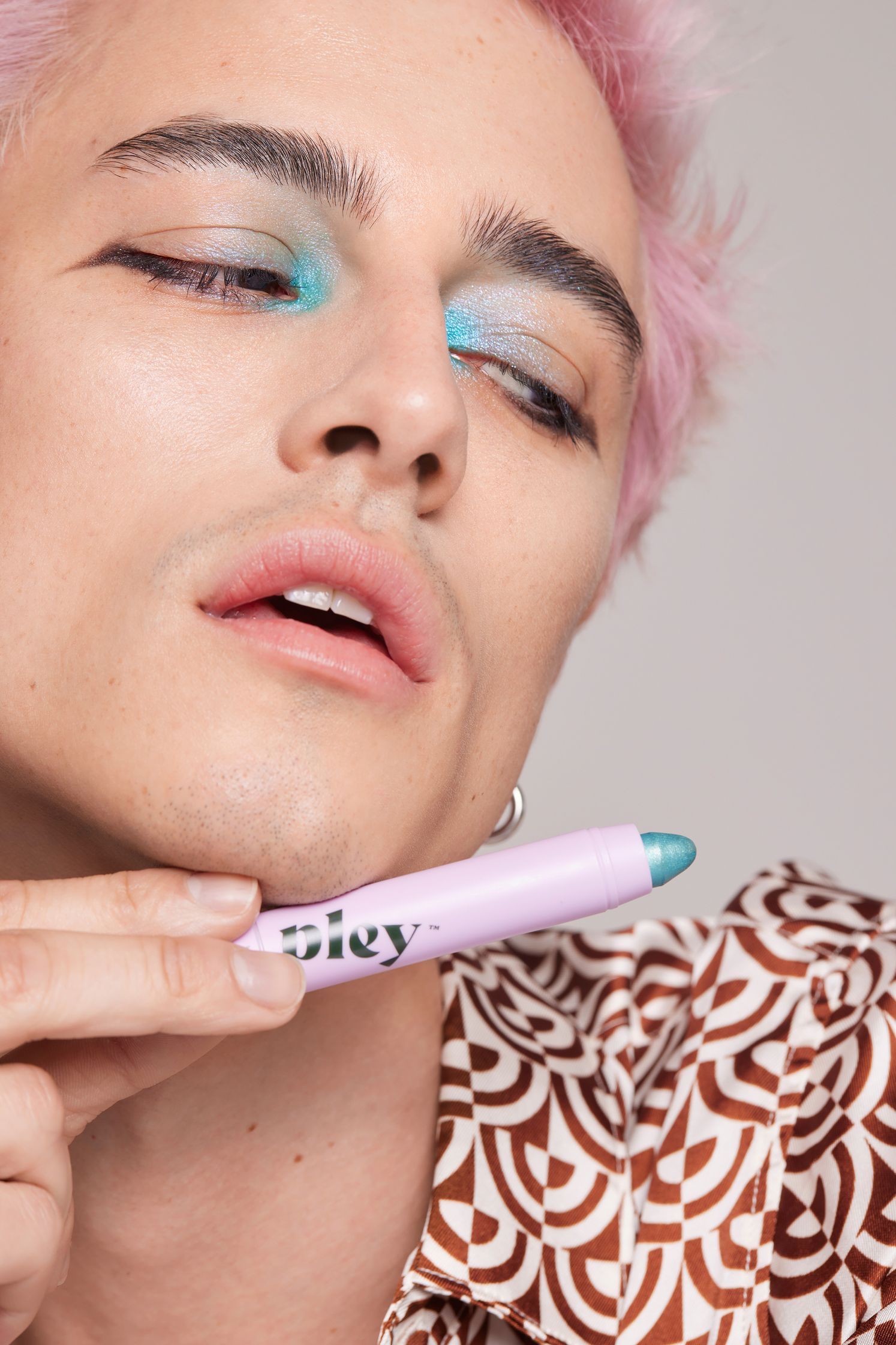 a man with a pink hair brushing his teeth