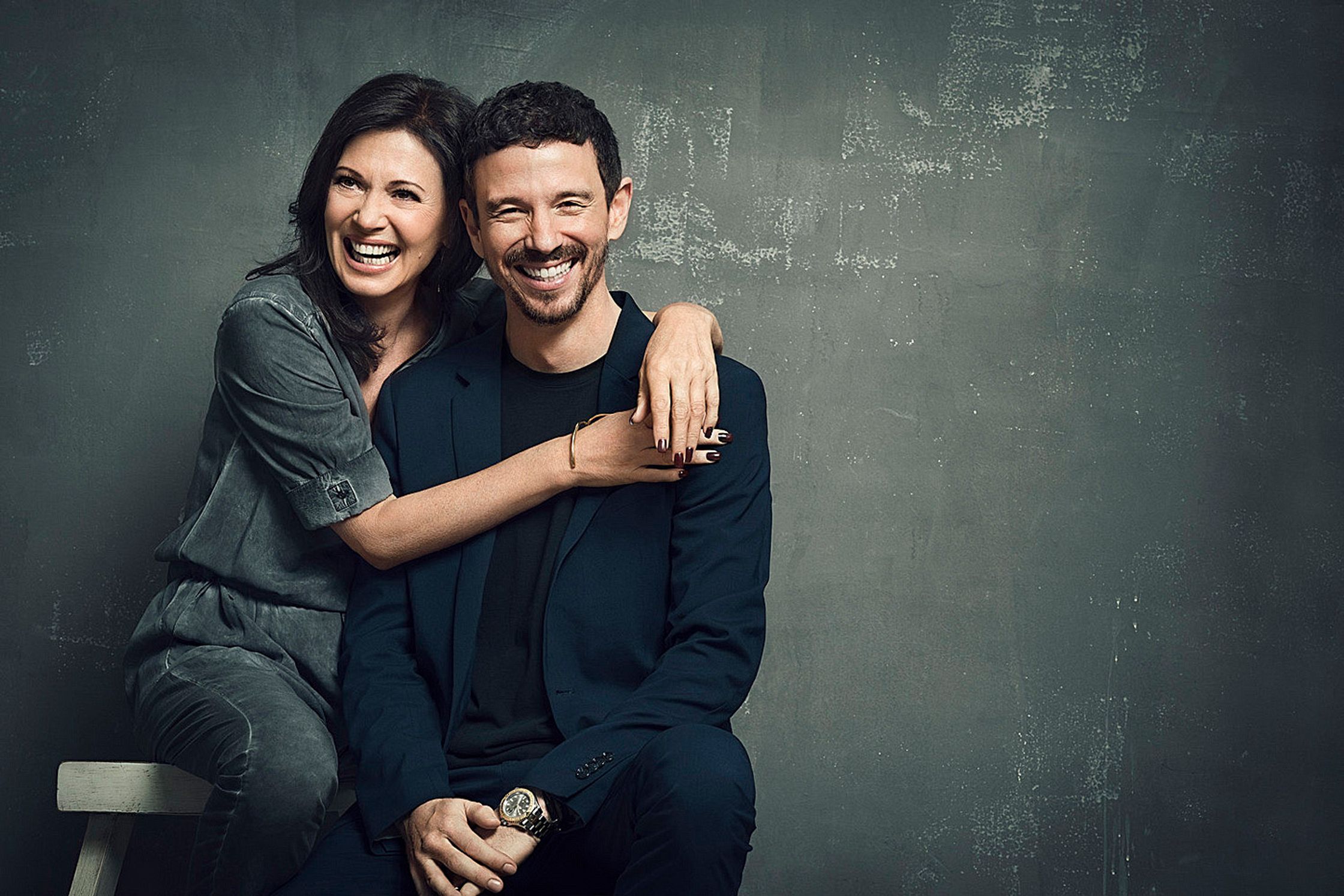 Iris Berben and Oliver Berben posing for a photo in front of a gray wall
Retouch Hamburg