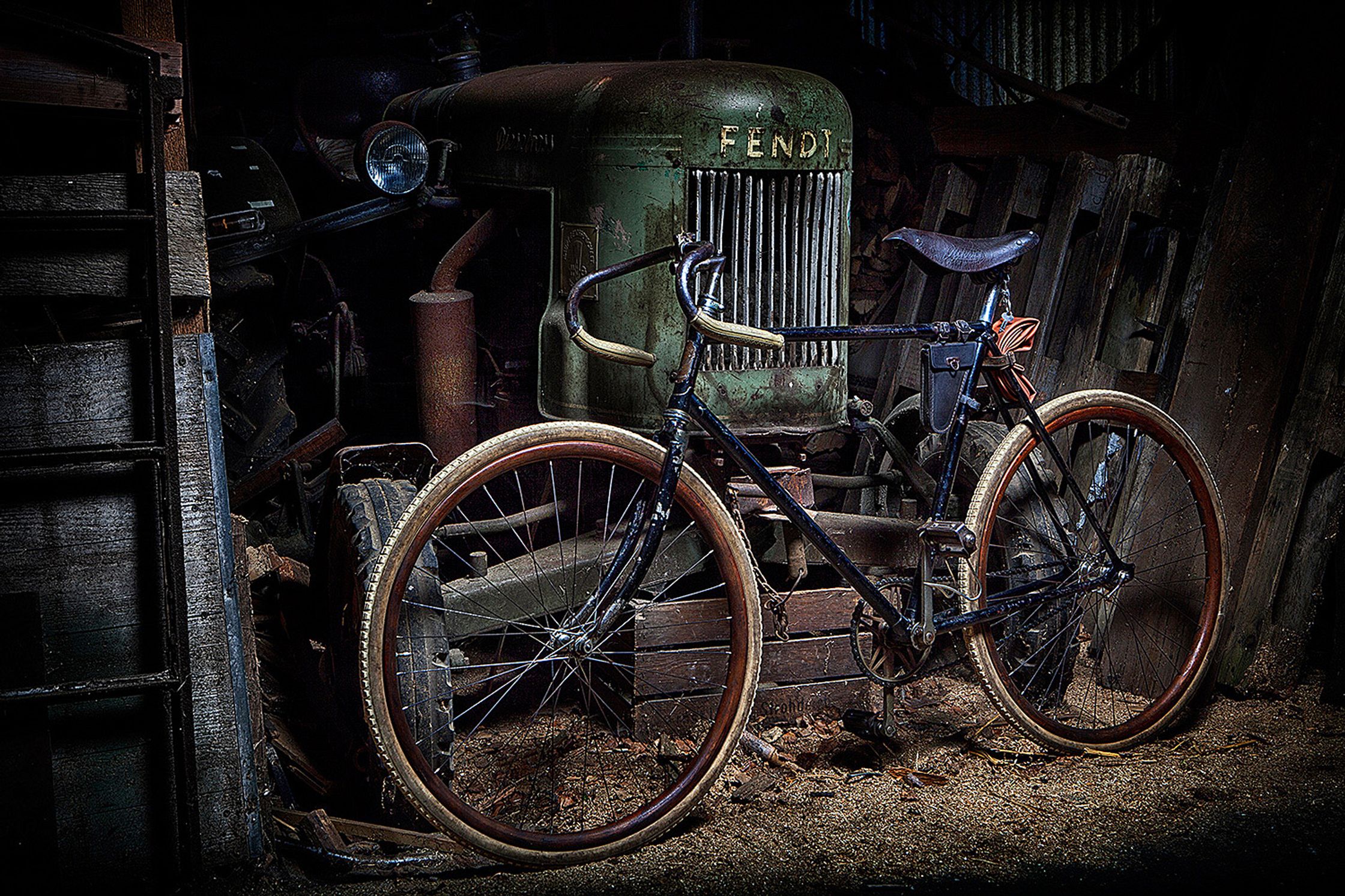 a old bike leaning against a tractor Bildbearbeitung Hamburg