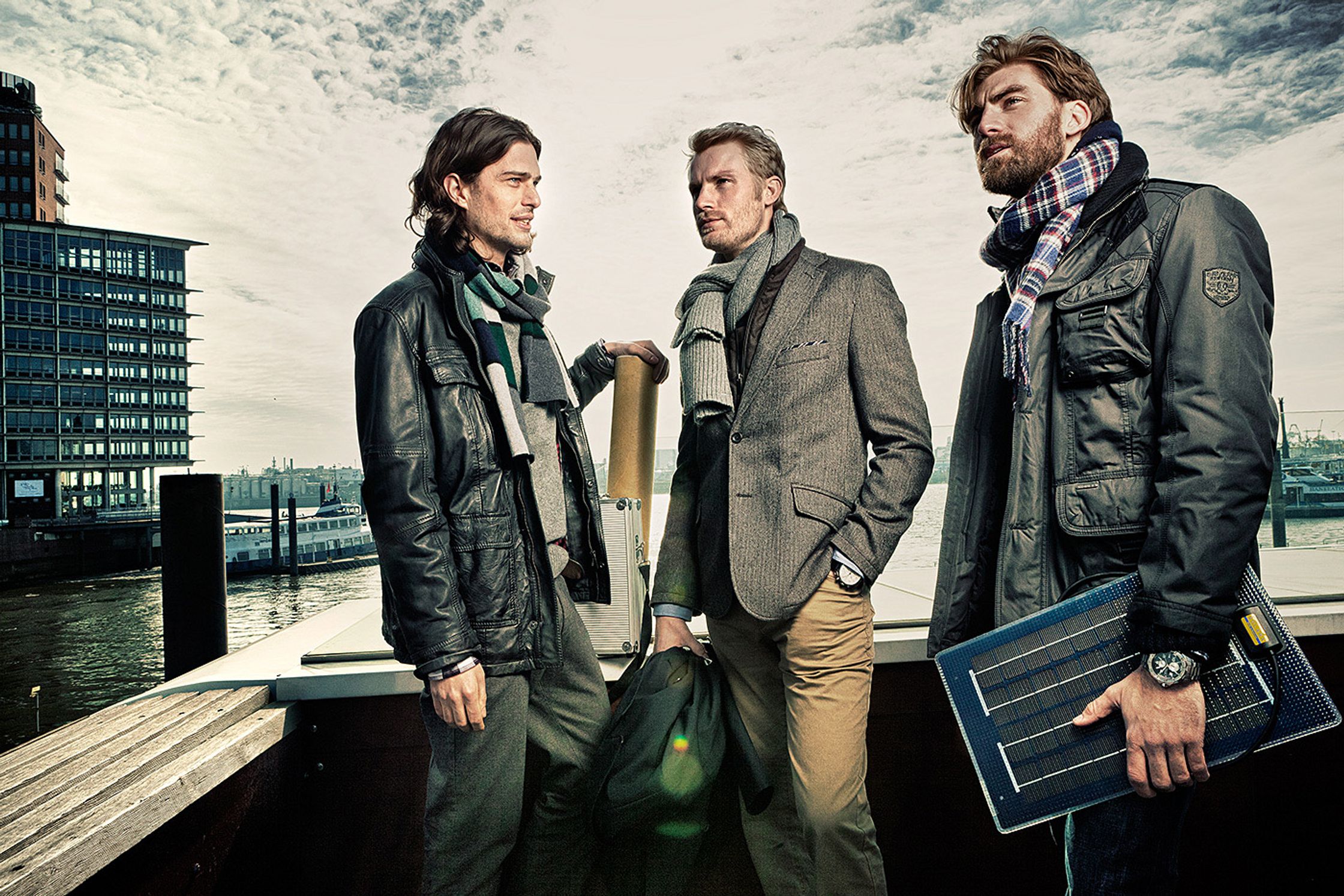 three men standing on a dock with a boat in the background Bildbearbeitung calamar fashion kampagne