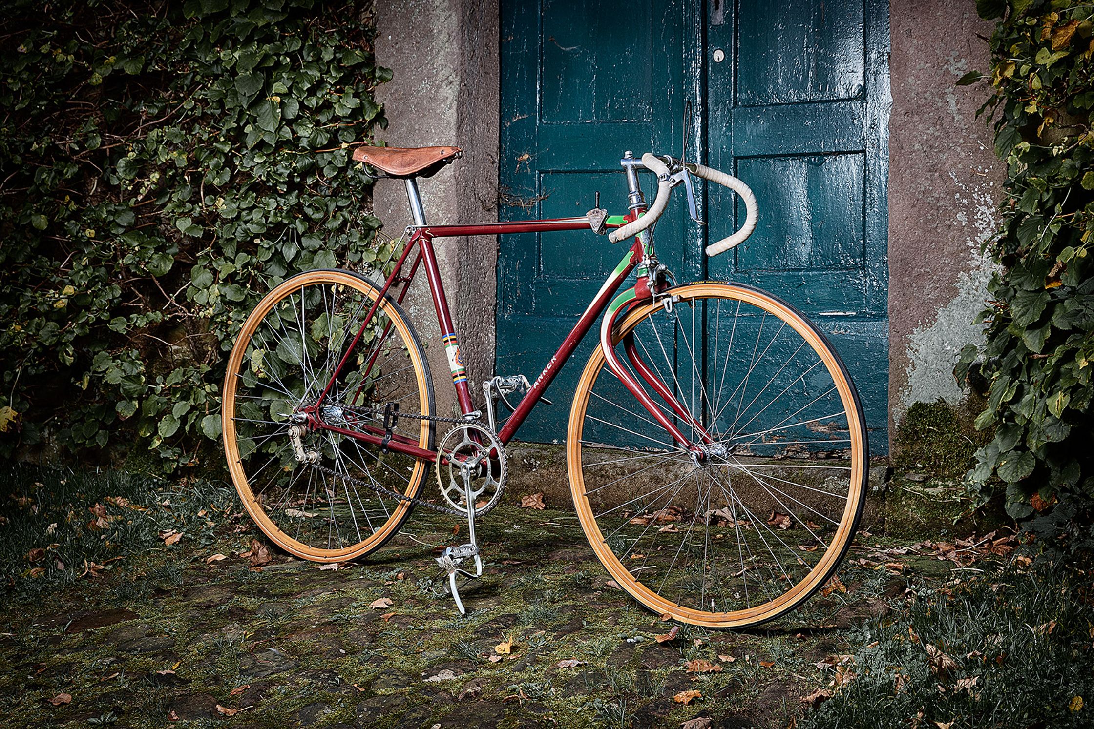 a red bicycle leaning against a brick wall product Post Production