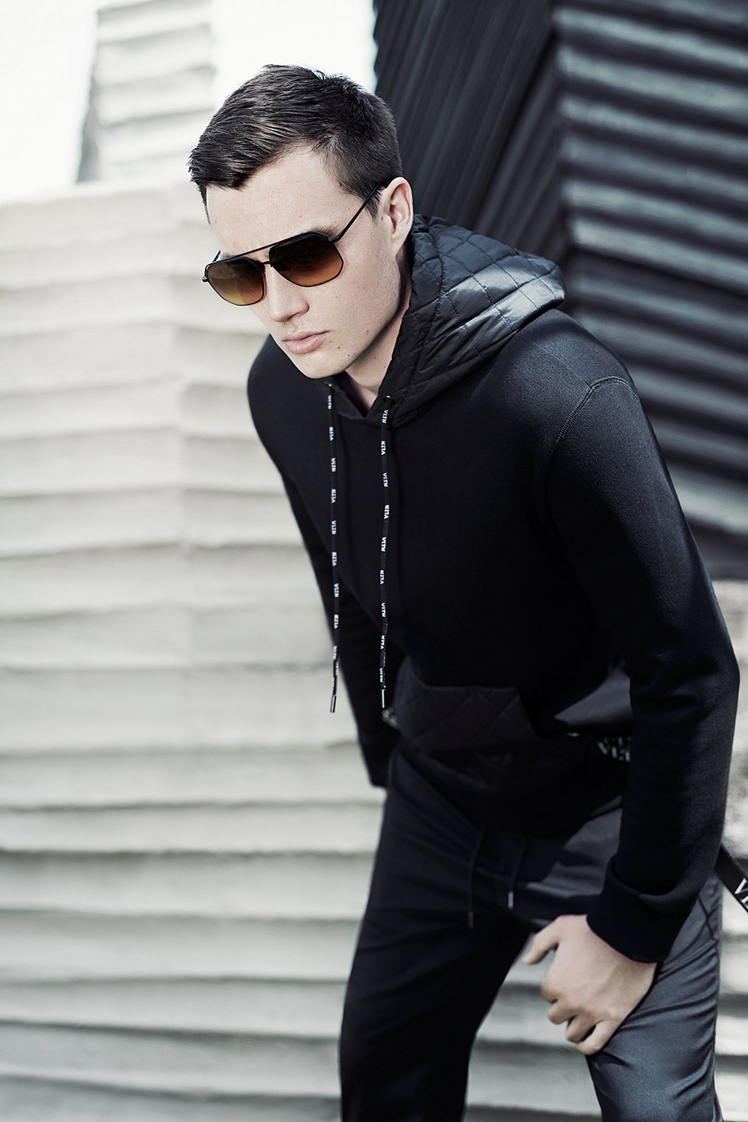 a young man wearing a black hoodie and sunglasses fashion post production