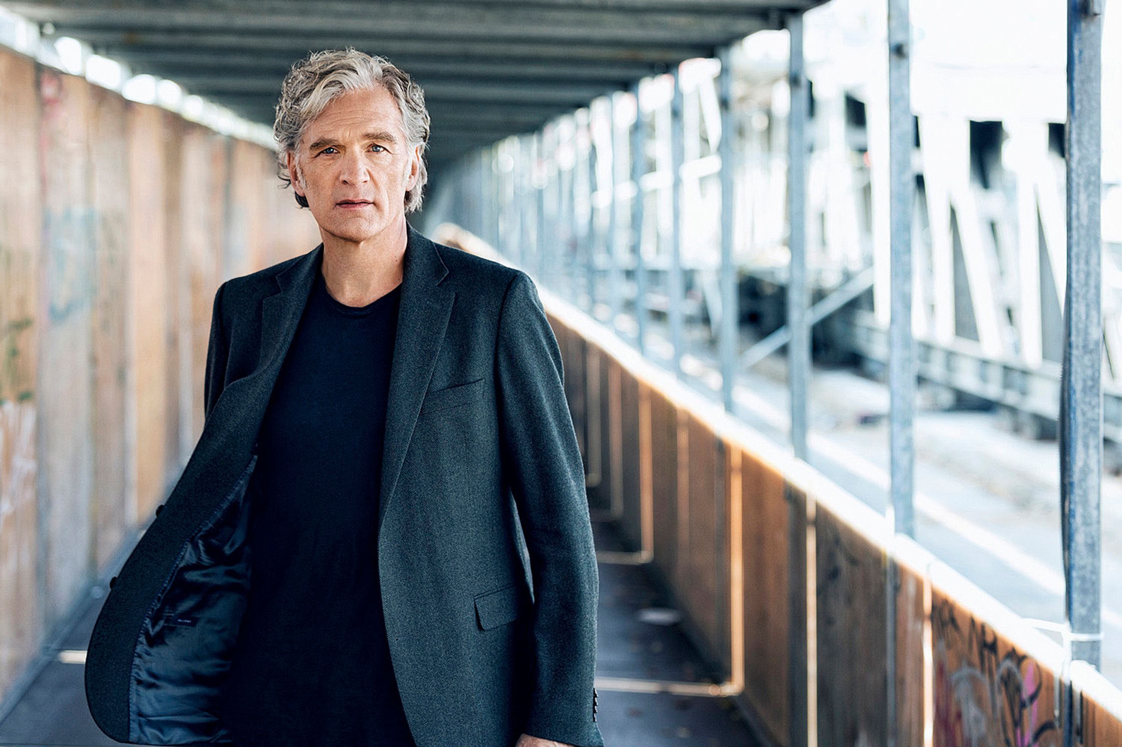 walter sittler in a black suit standing under a bridge
post production by glamtouch