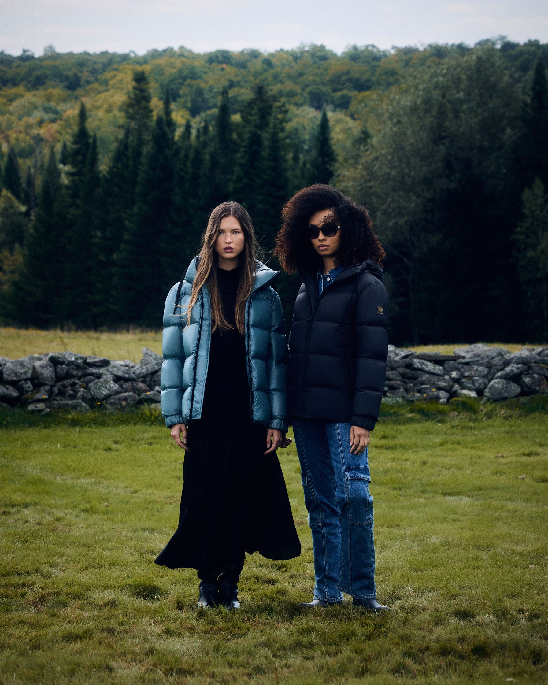 two women standing in a field wearing puffer jackets