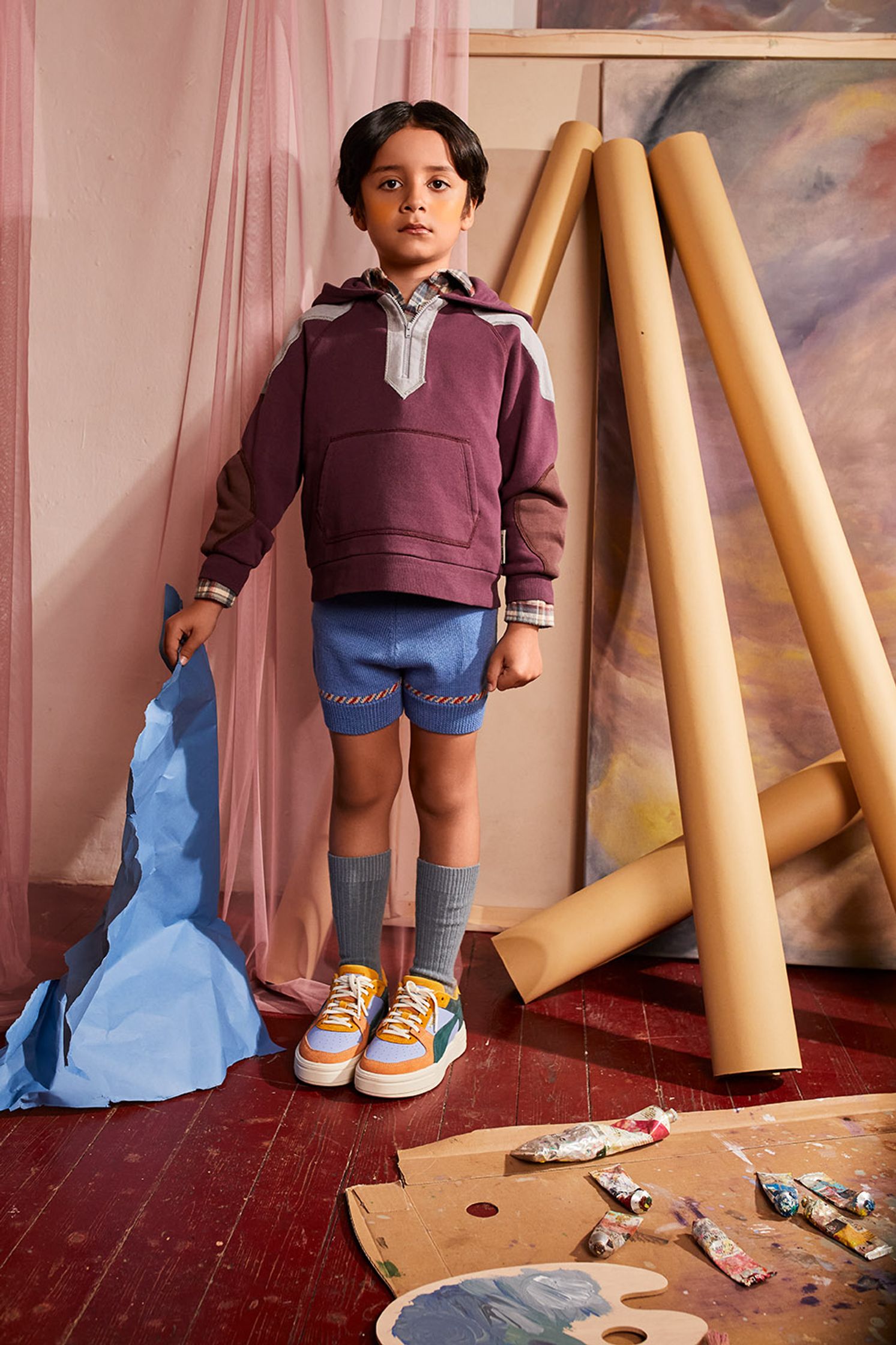 a young boy standing in front of a painting