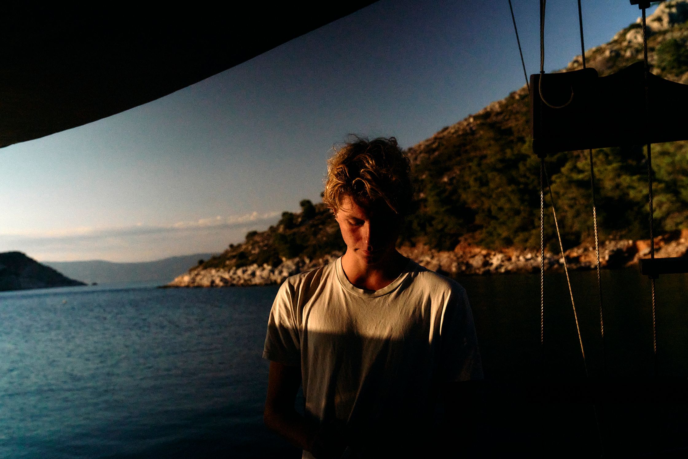 a man standing on a boat looking at the water