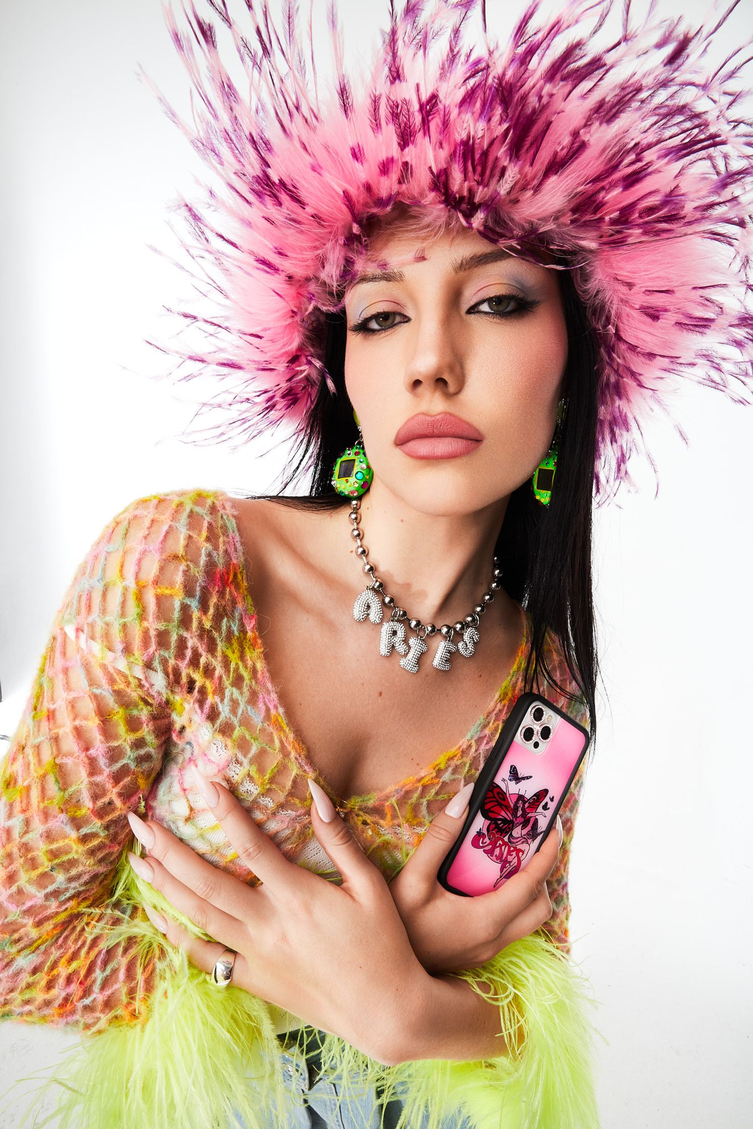 a woman wearing a pink feathered hat holding a phone