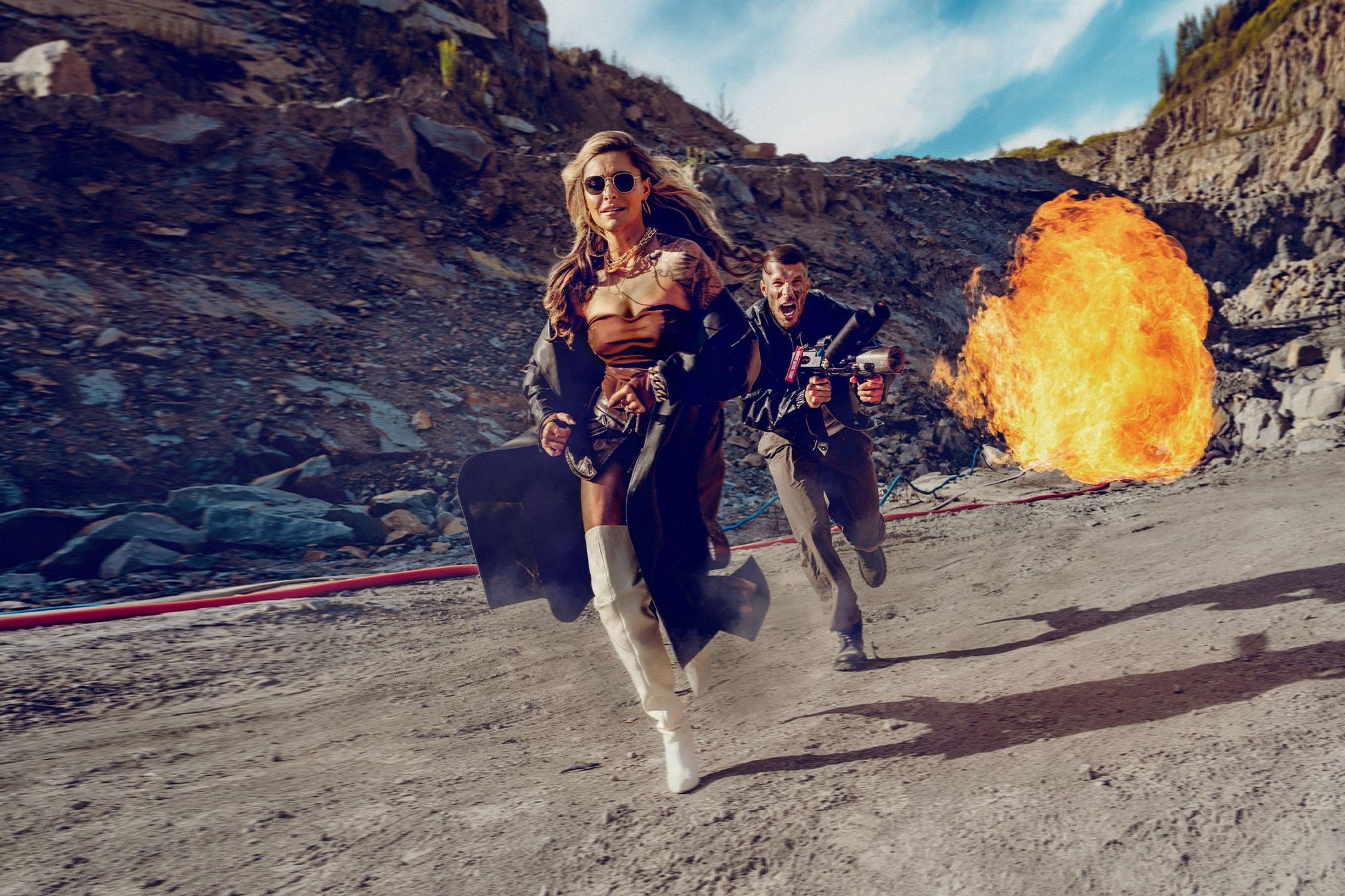 a man and woman running through a desert with a fireball