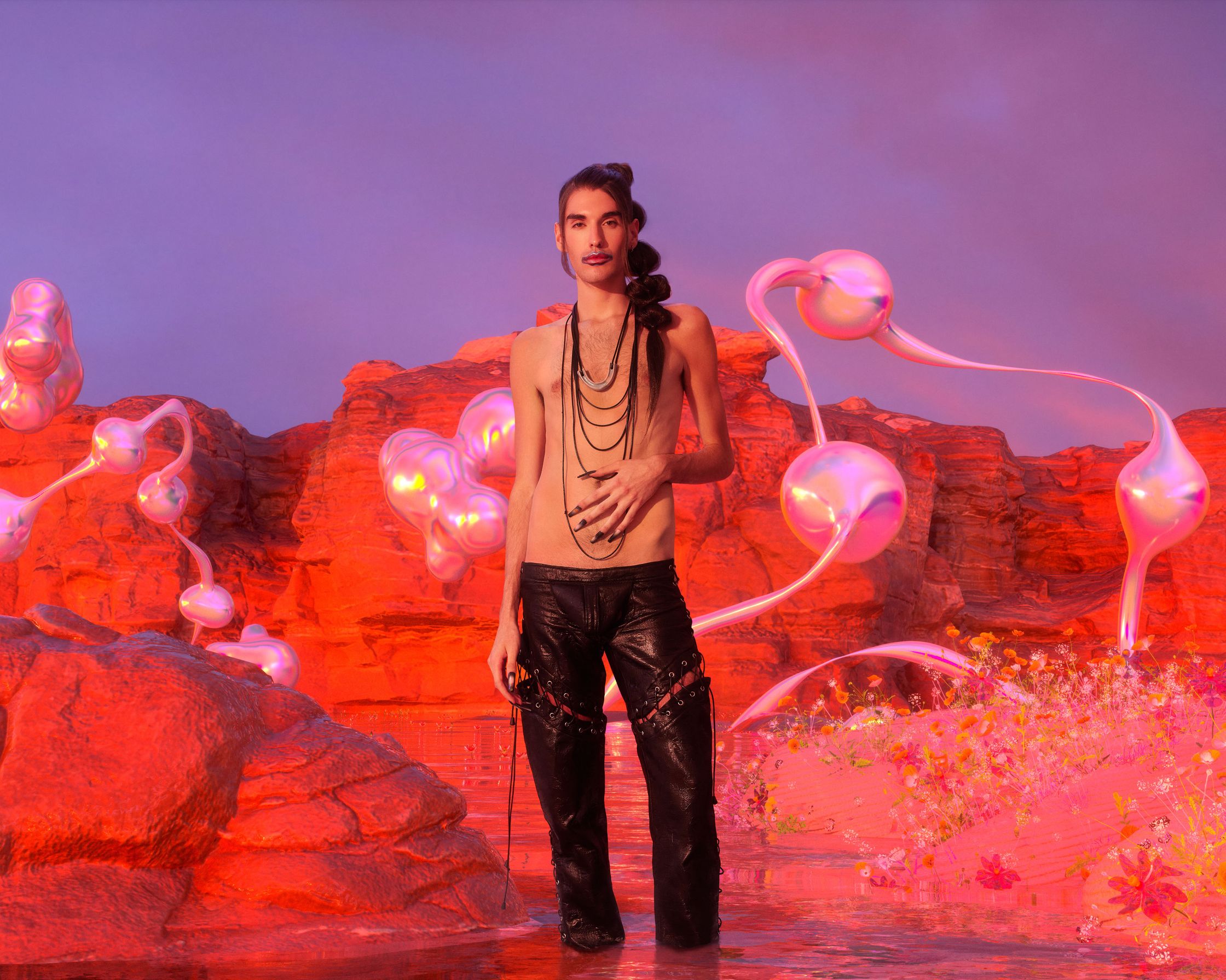 a man standing in the water next to a pink flower