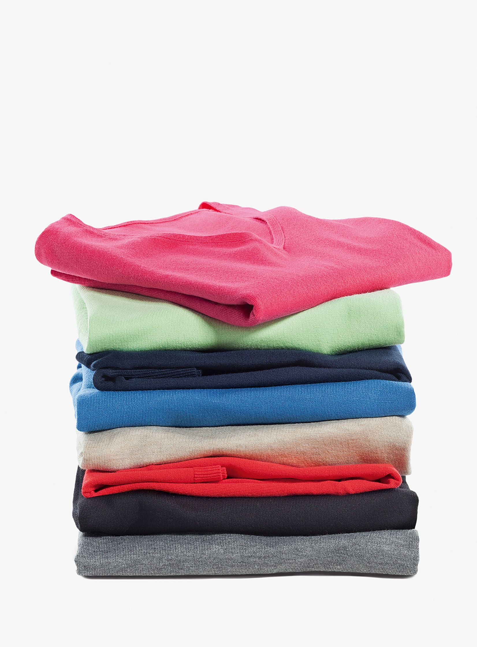 a stack of colored t - shirts on a white background commercial composing