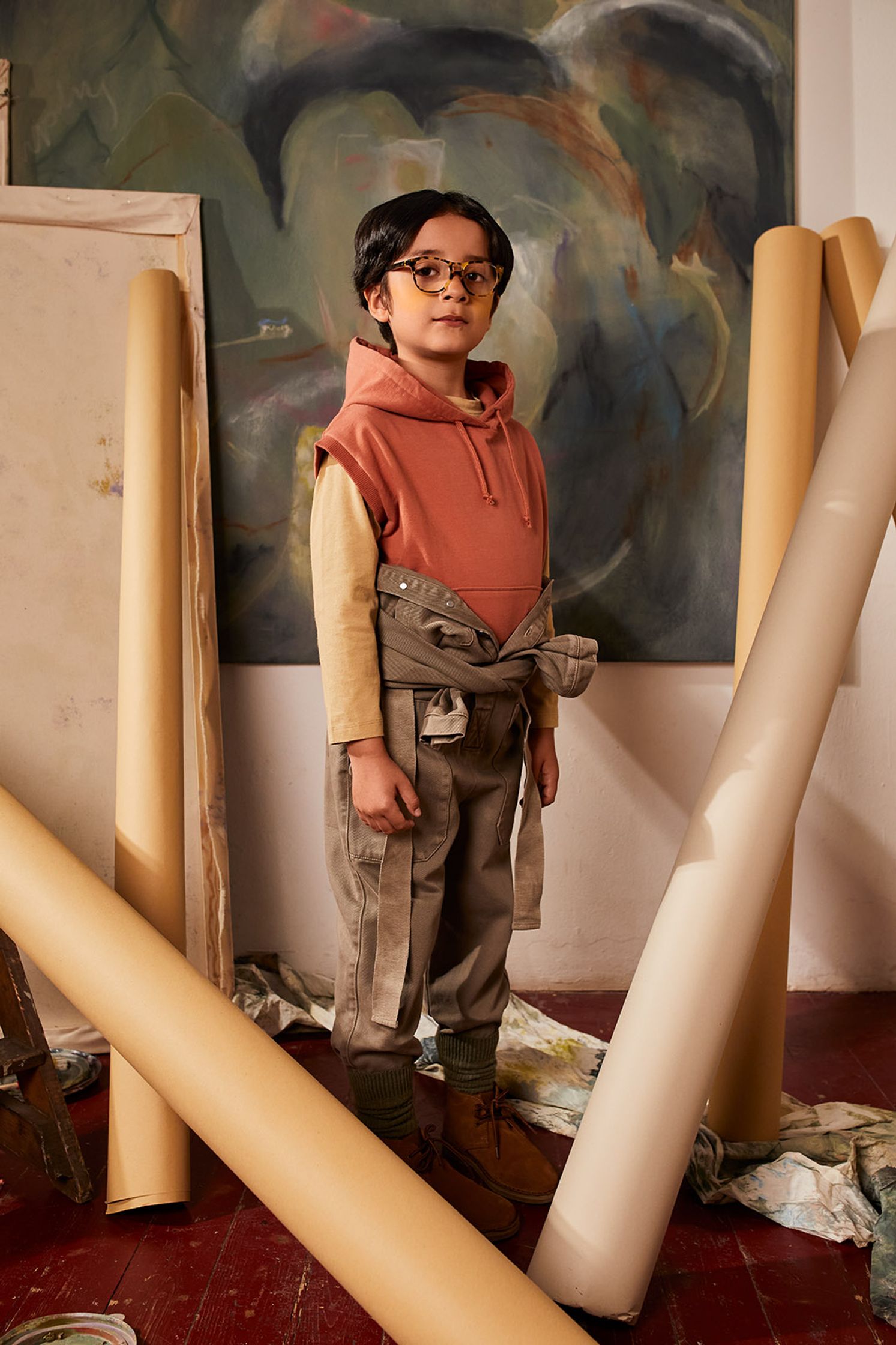 a young boy standing next to a roll of paper