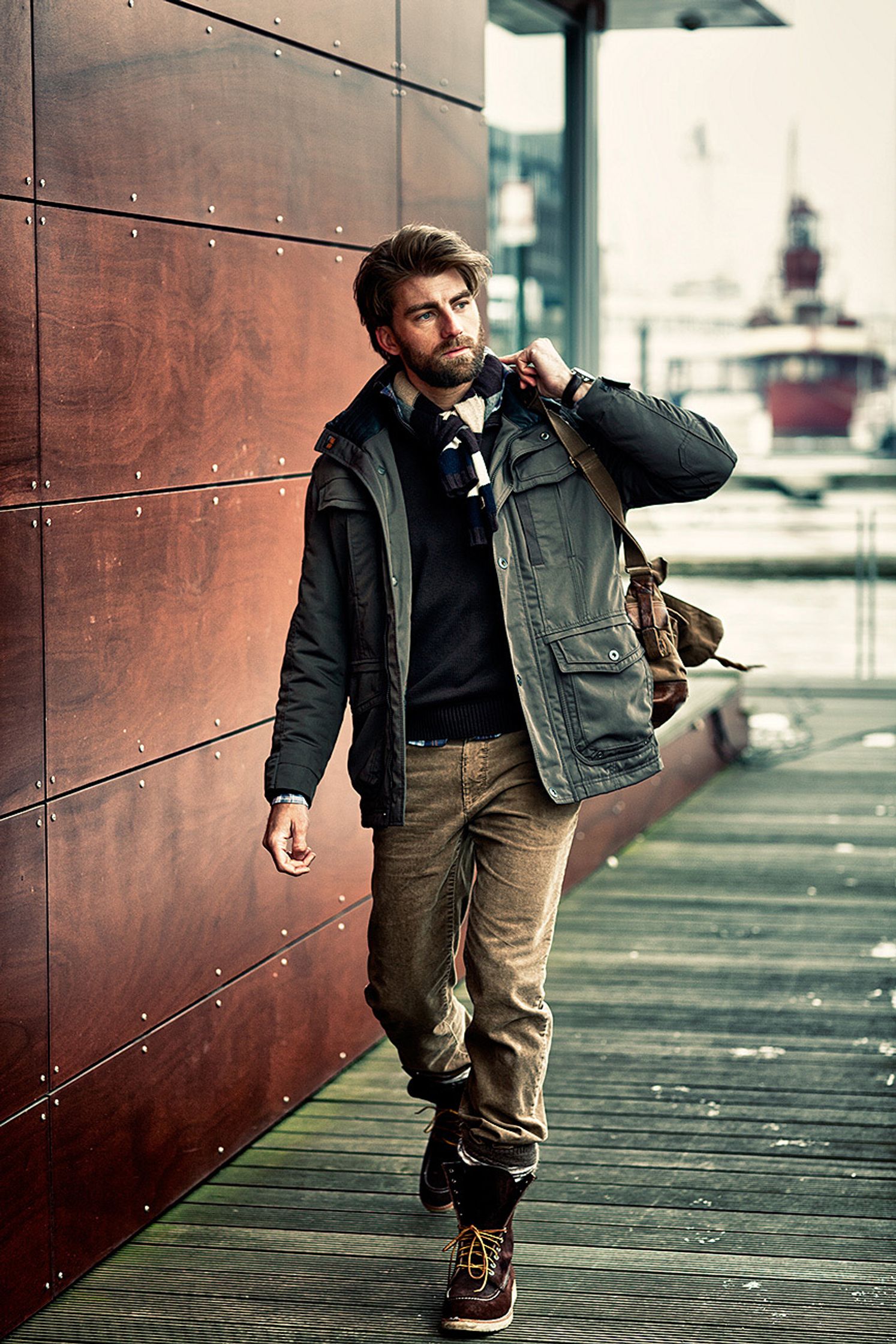 a man walking down a sidewalk with a backpack Bildbearbeitung calamar fashion kampagne