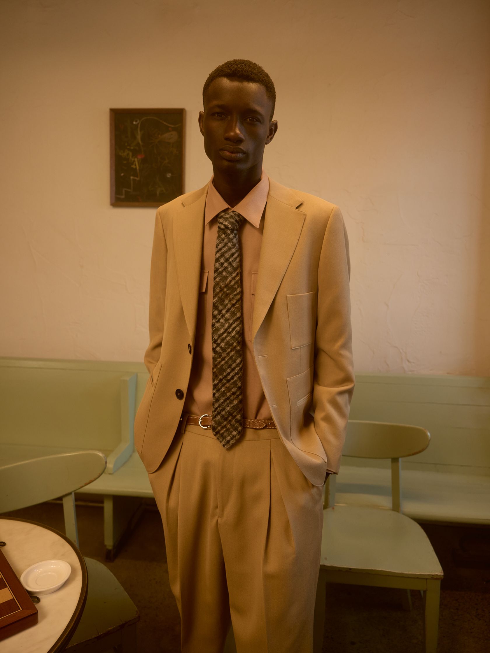 a man in a tan suit standing in a room