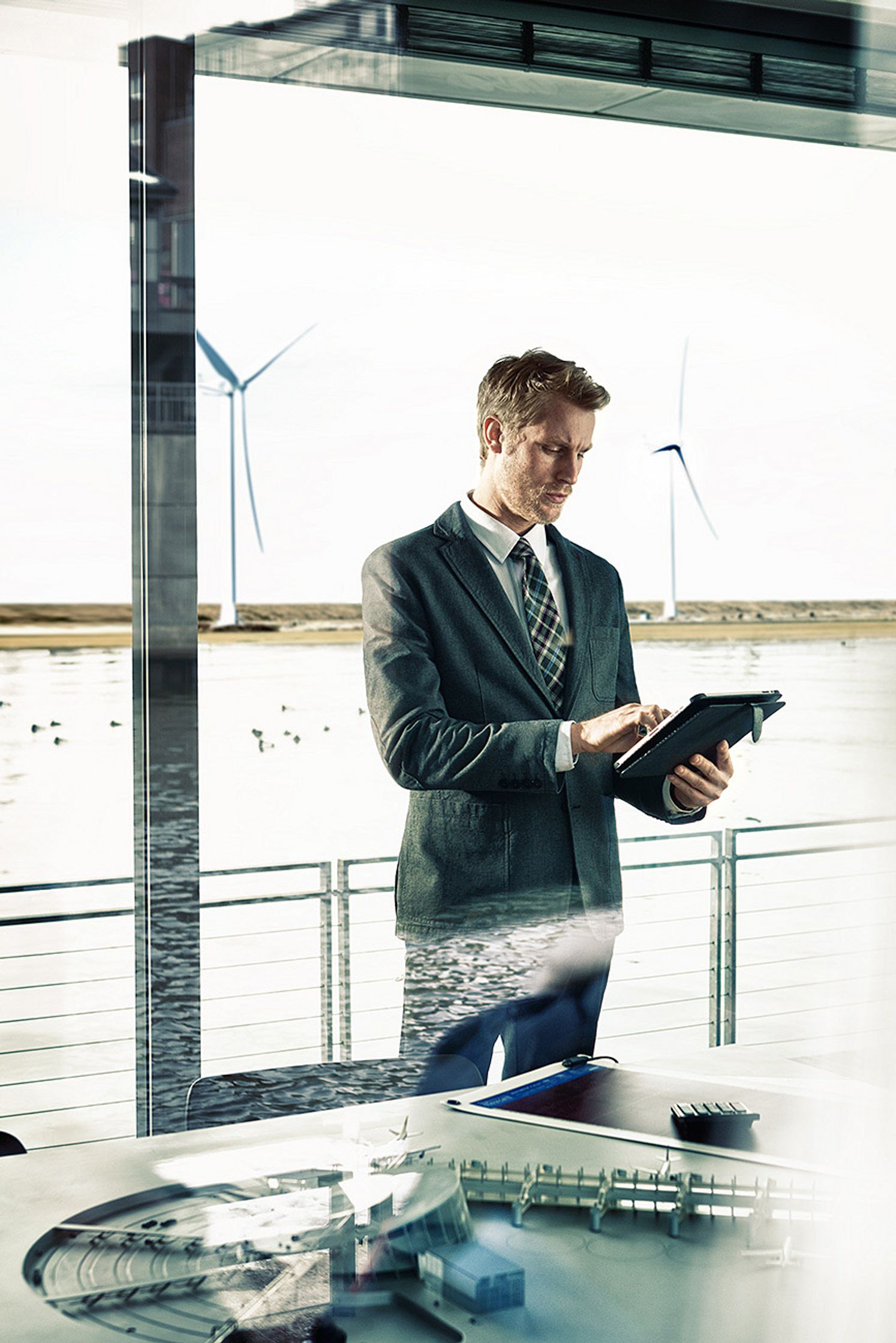 a man in a suit standing in front of a window Bildbearbeitung calamar fashion kampagne