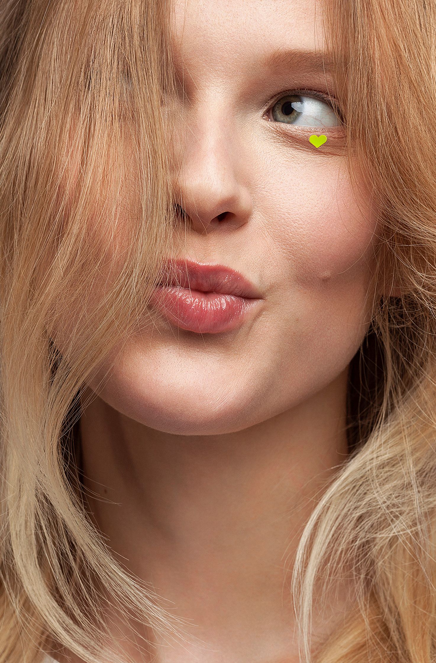 a woman with blond hair is making a kissy face beauty retusche